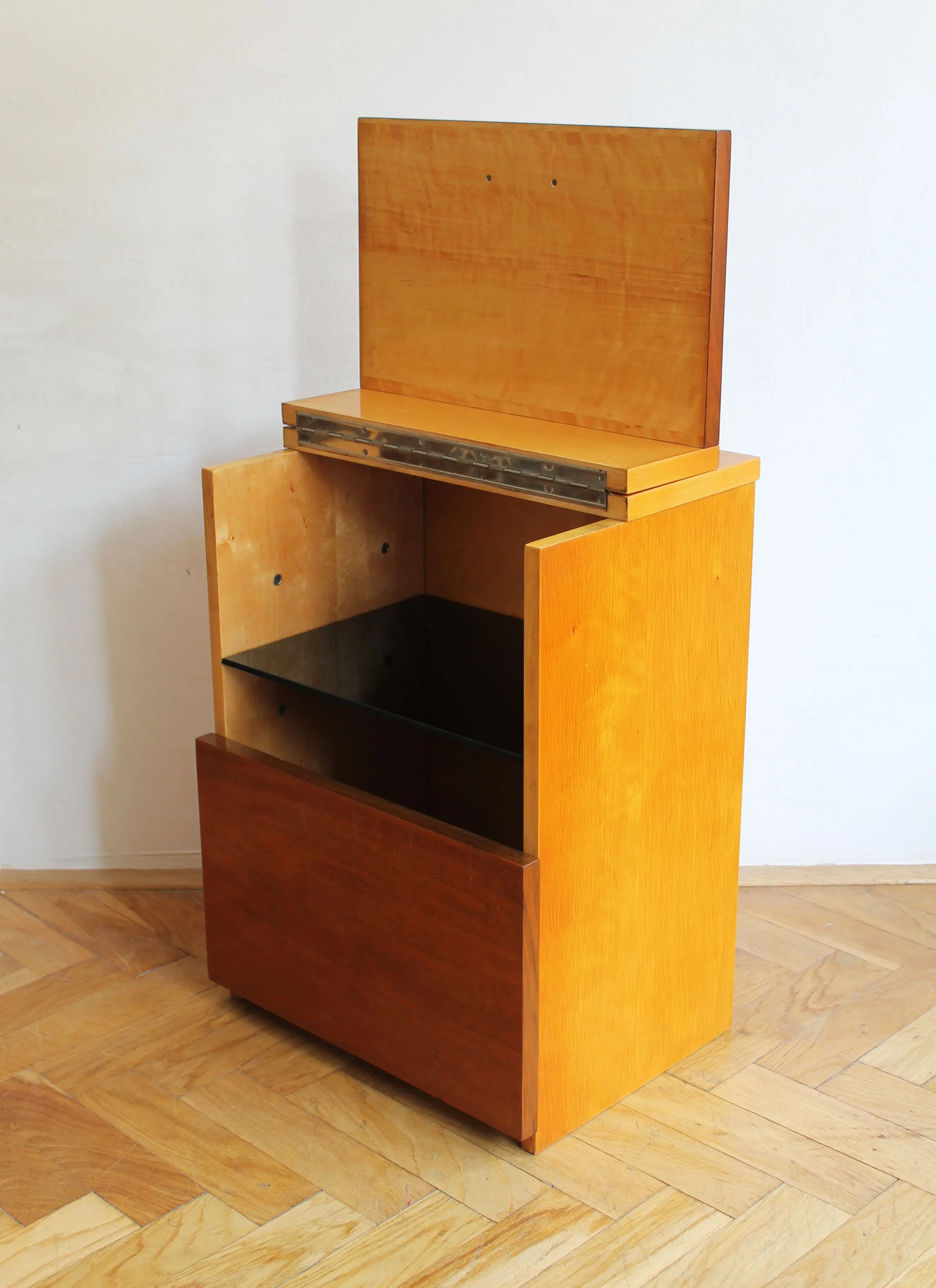 Closed mid-century cabinet showing warm wood grain and clean lines