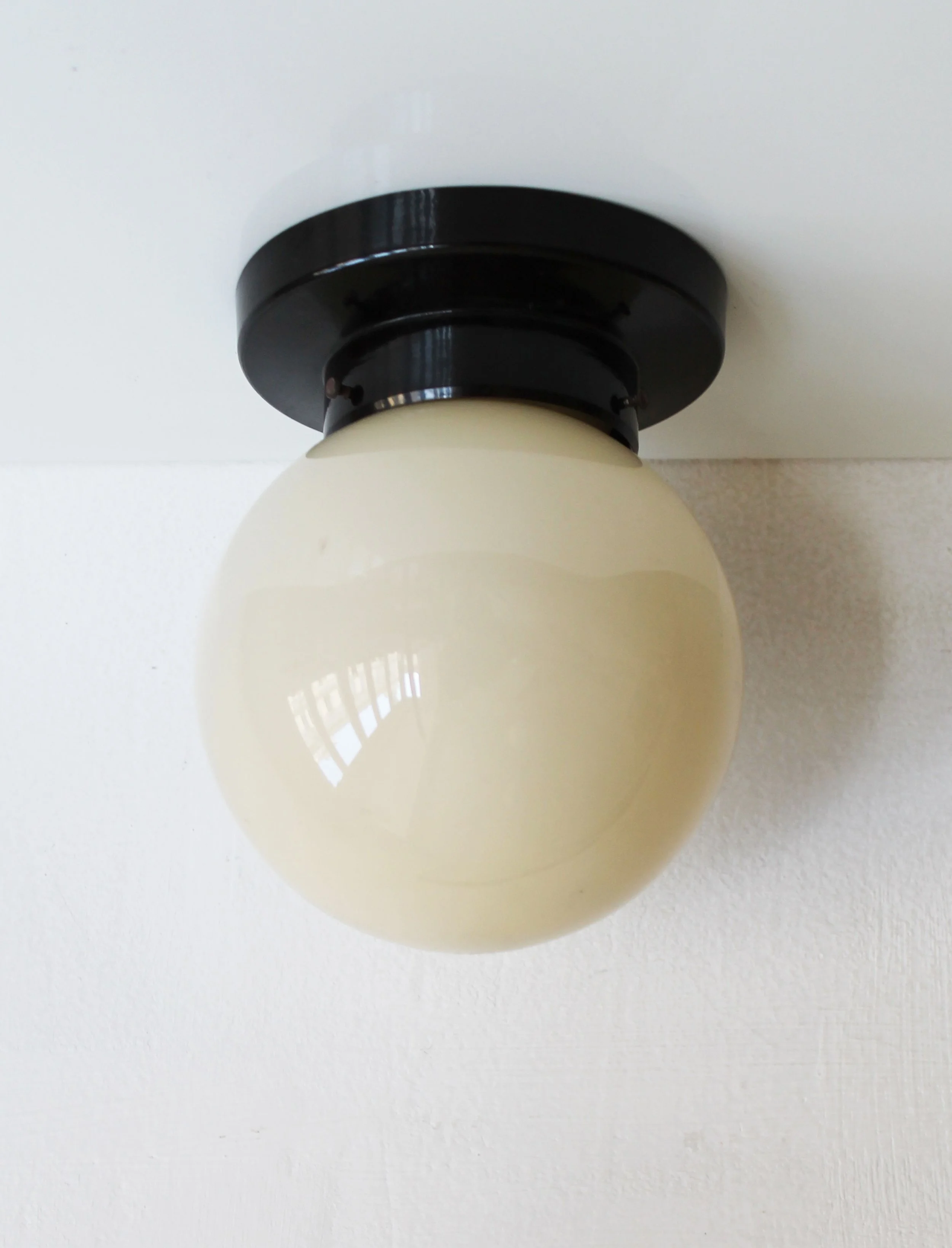 Black bakelite base ceiling light milk glass globe.jpg