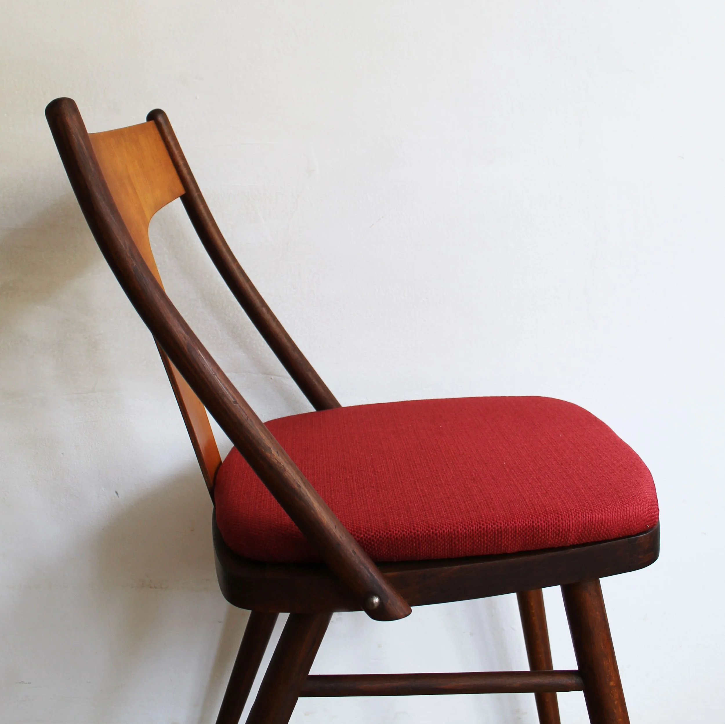Red upholstered mid-century chairs with curved wooden details.jpg