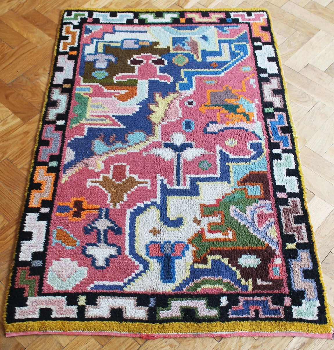 Vintage abstract motif rug showing minor edge wear.jpg