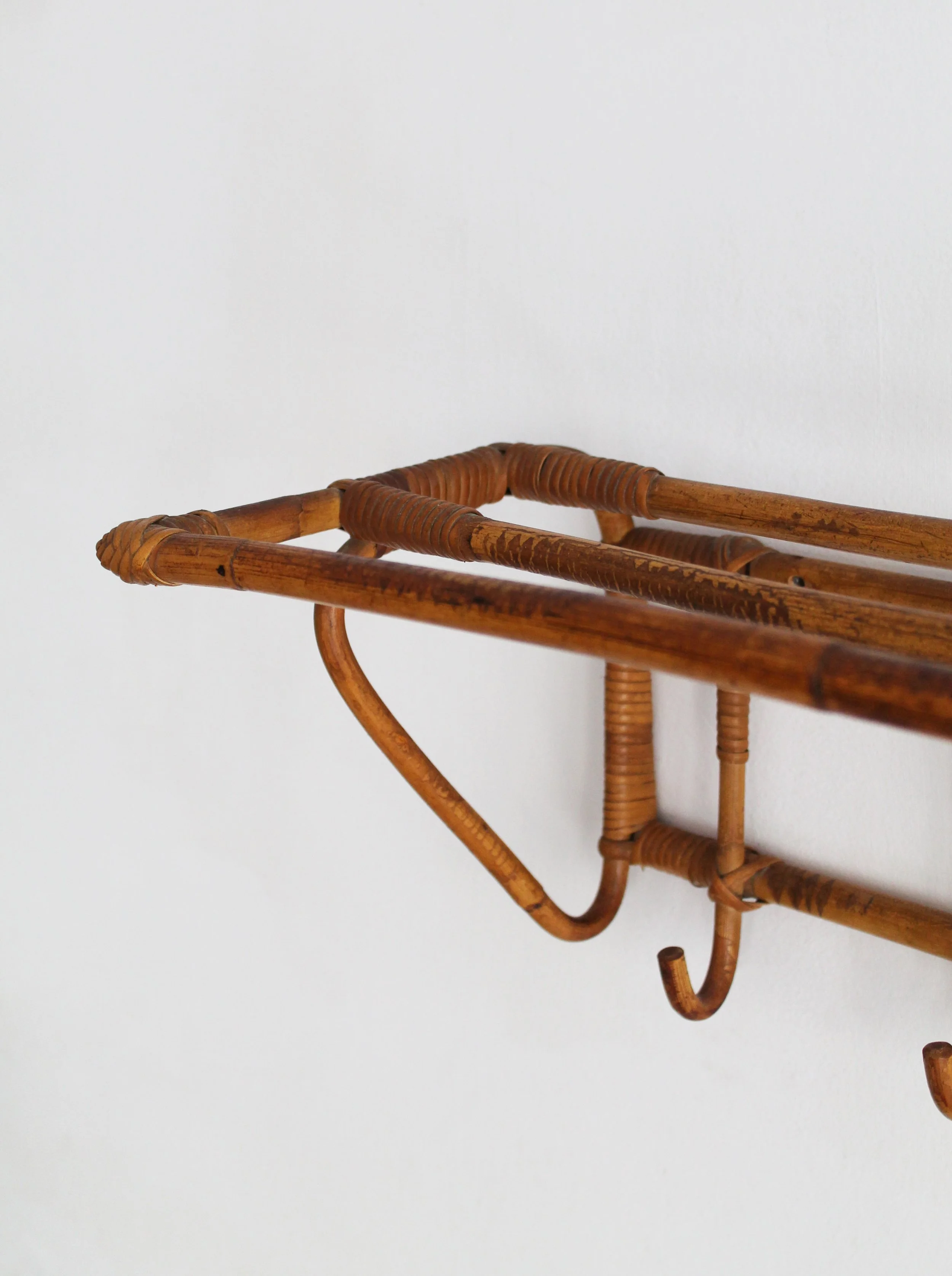 Curved cane side support and woven bindings on 1960s rattan coat rack.jpg