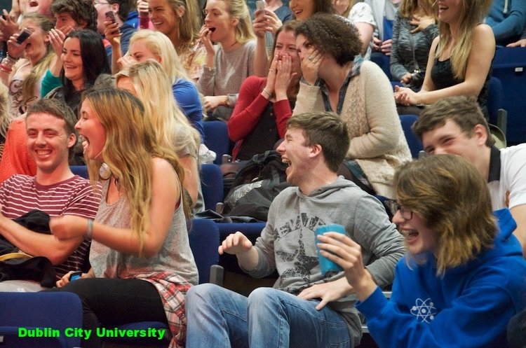 Audience laughing at friends being hypnotized