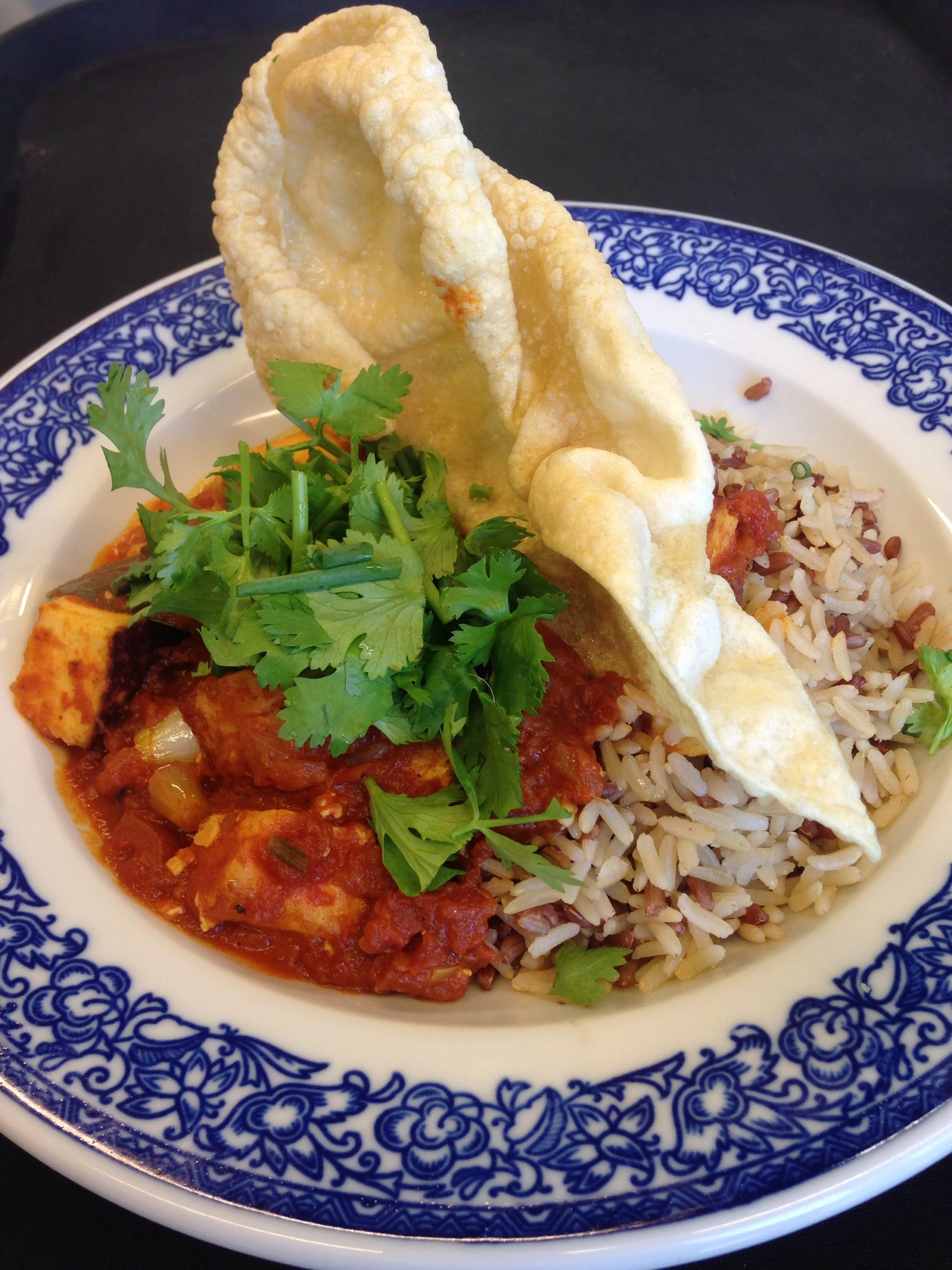 Paneer an cremiger Tomatensauce (indisch gewürzt) mit Vollreis, Koriander und Pappadam