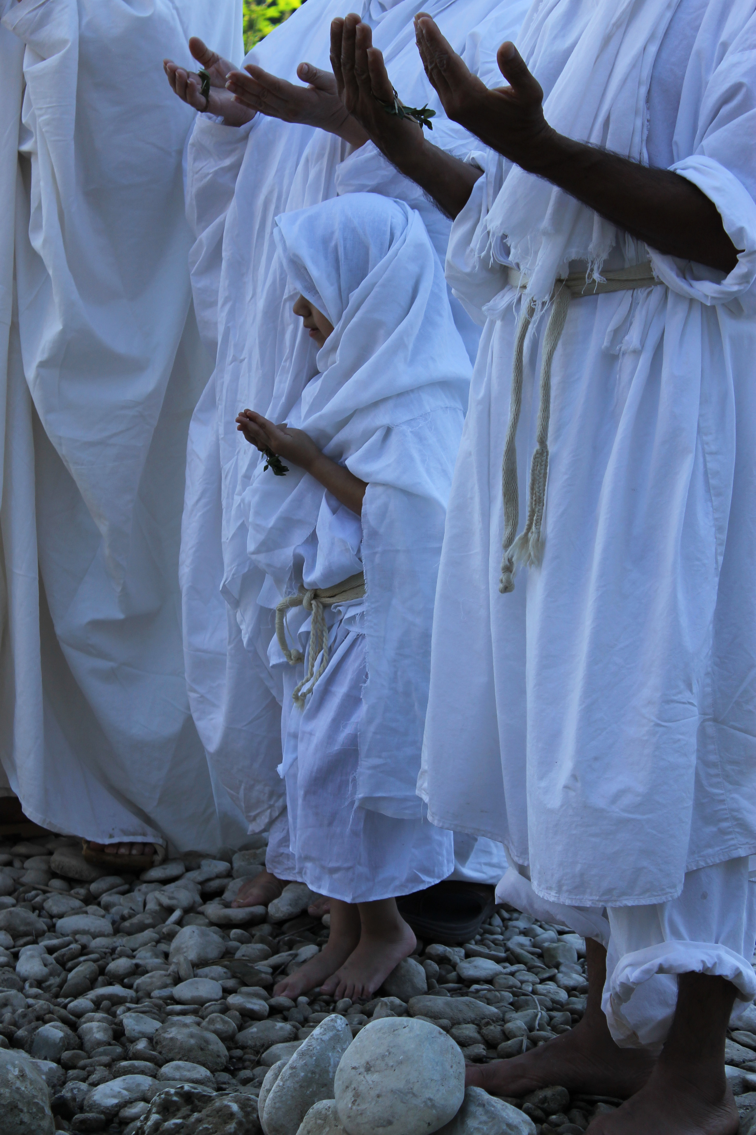 Community members pray to the river, asking it to witness the ceremony. The Mandaeans perform baptisms at important milestones in their lives, like birth, and even death. This is five-year-old Elssa Ebad's first baptism.