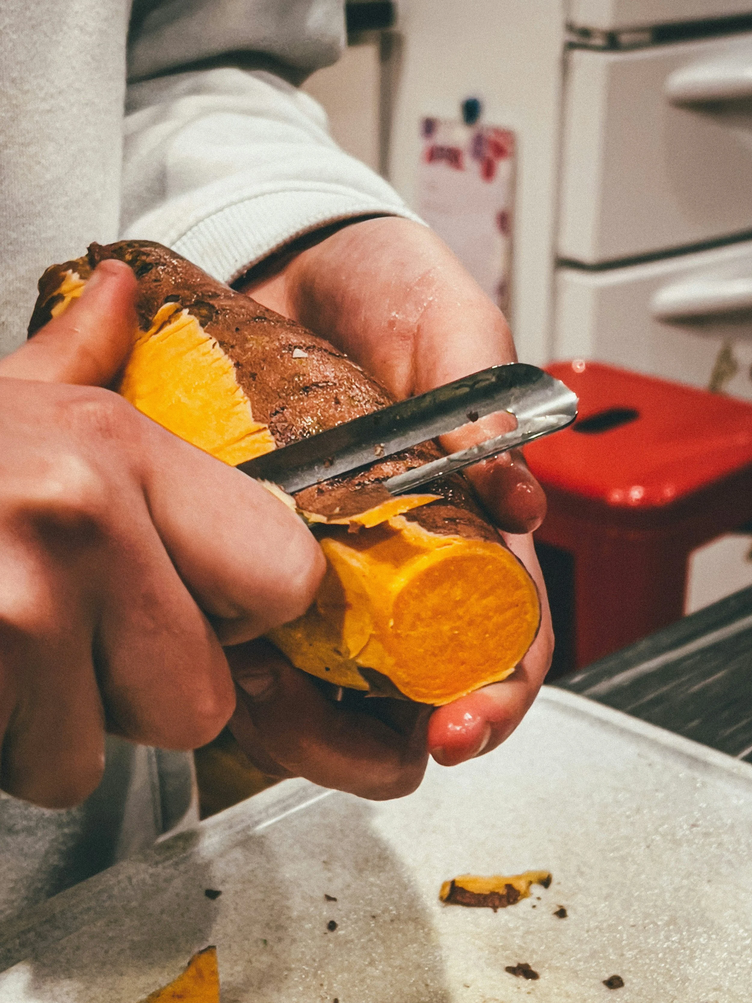 a person peeling a sweet potato