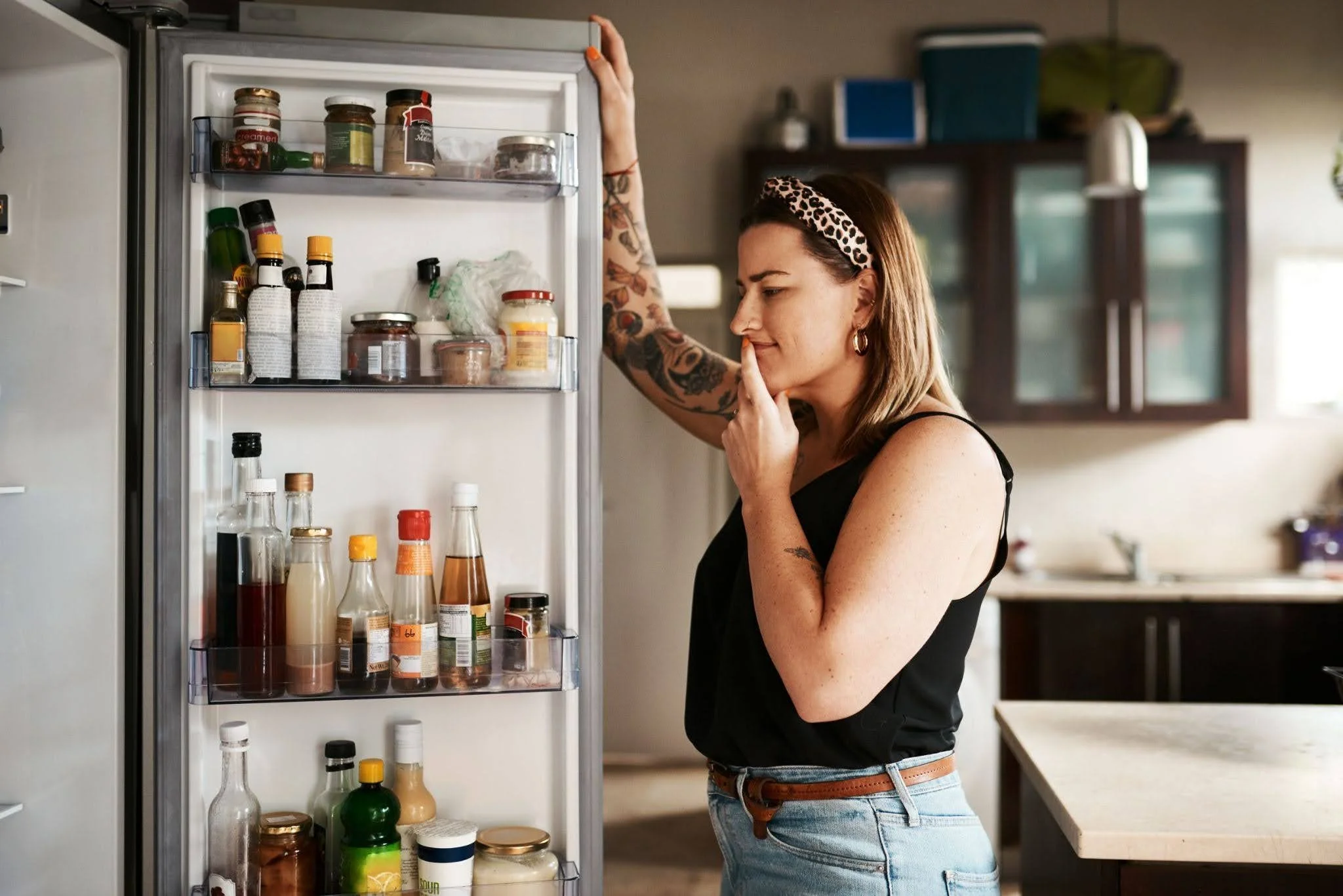 A young woman looking into the fridge to find food
