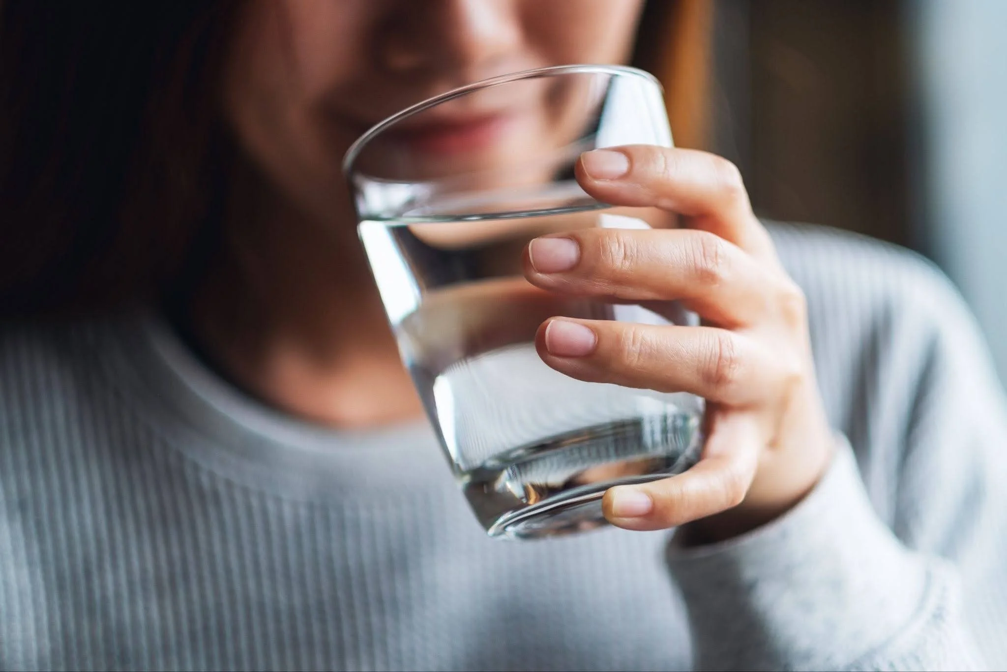 a woman drinking water while on GLP-1 medication