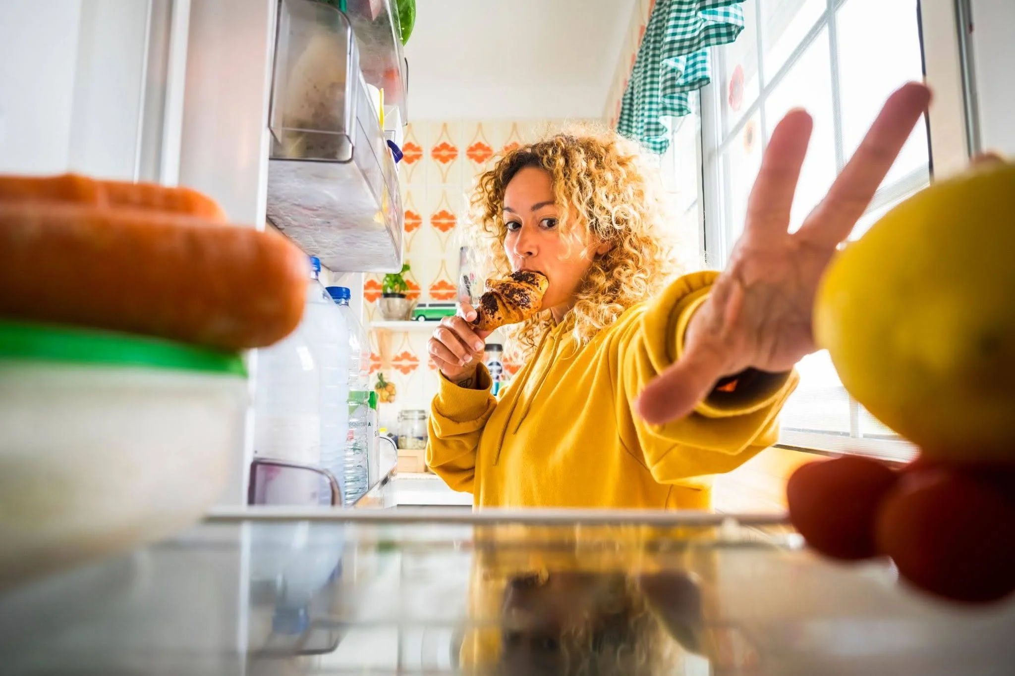 a woman grabbing snacks from the fridge