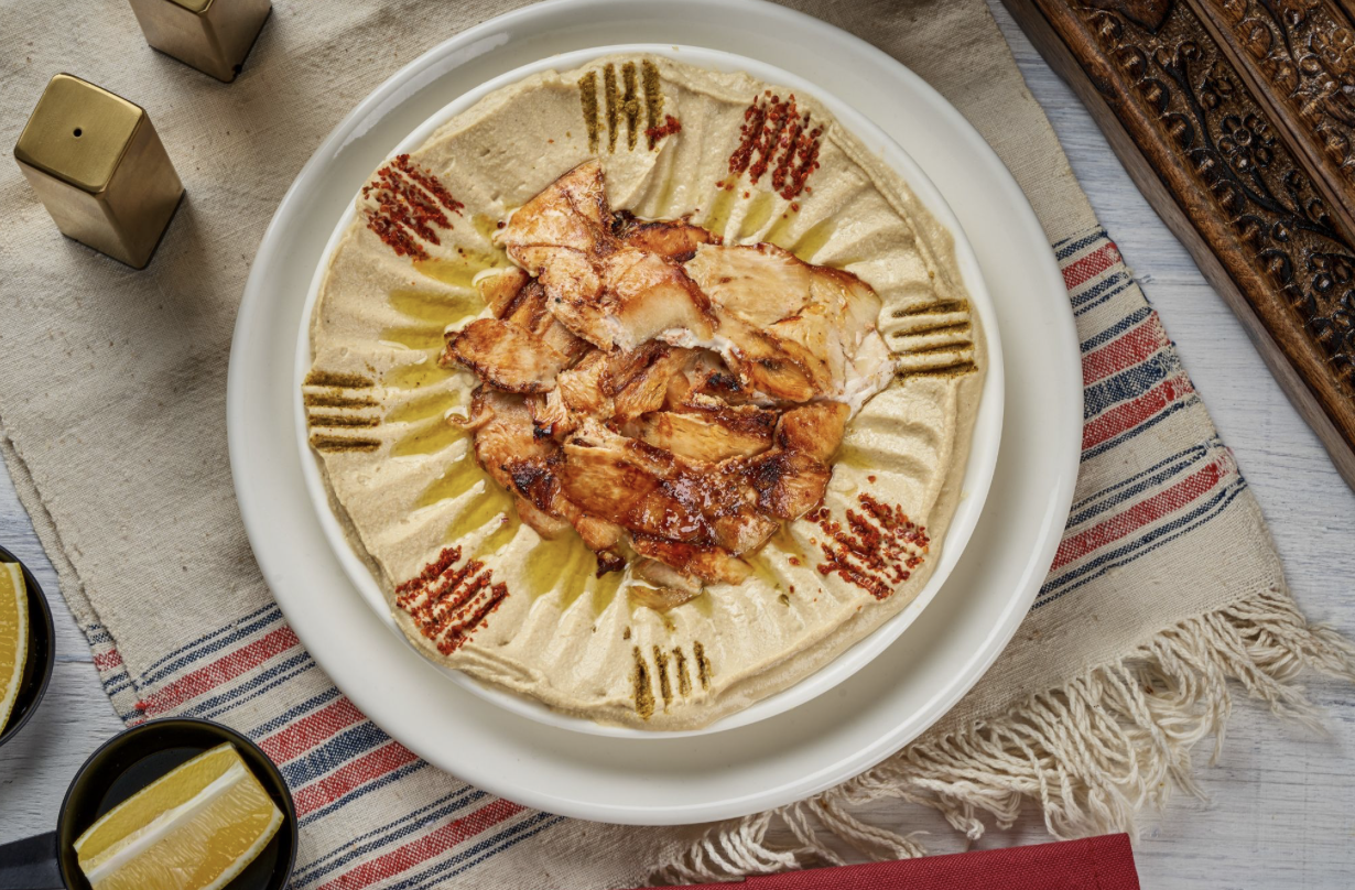 a plate with hummus and thin-cut chicken
