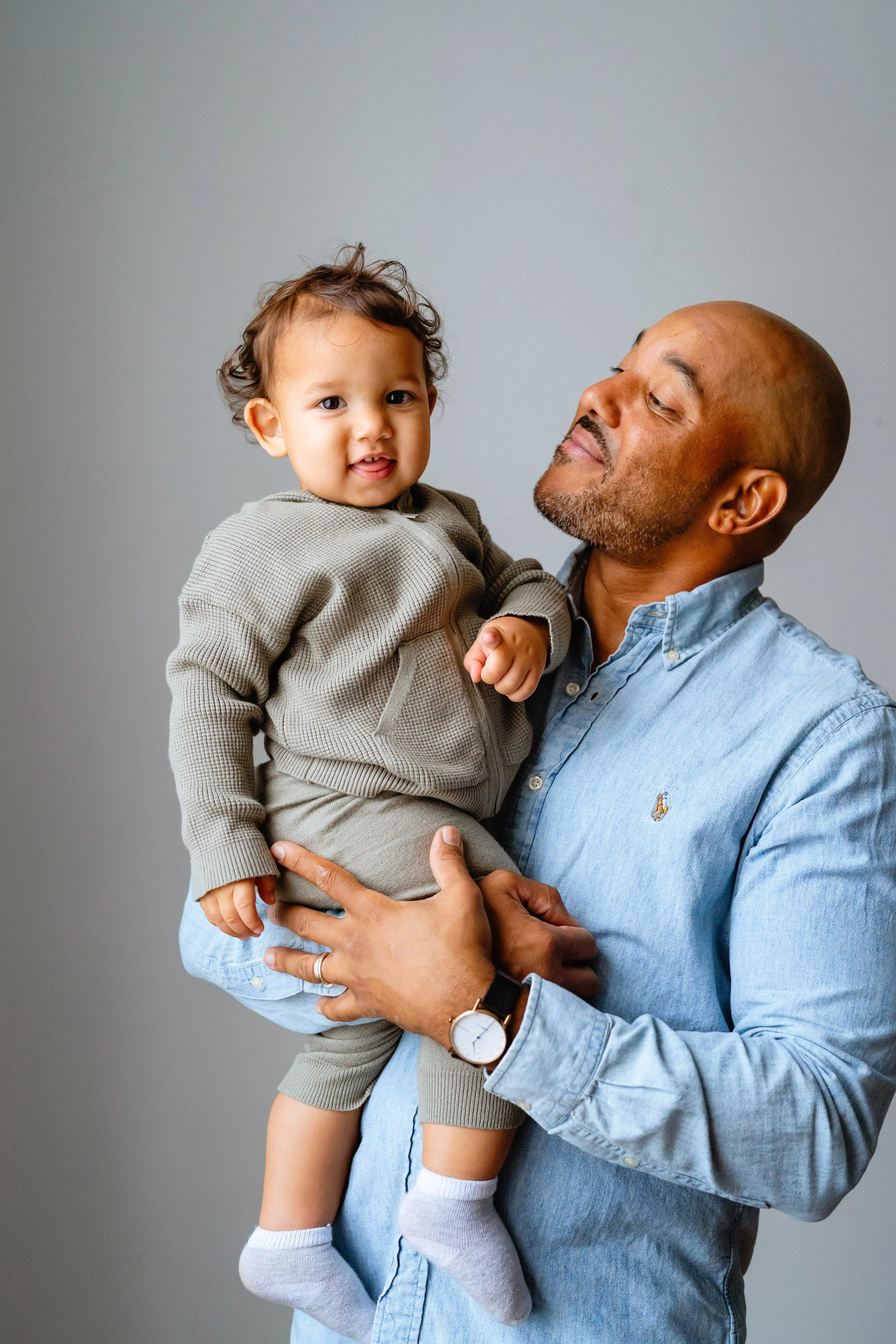 dad poses with baby son for professional family photos in tampa florida