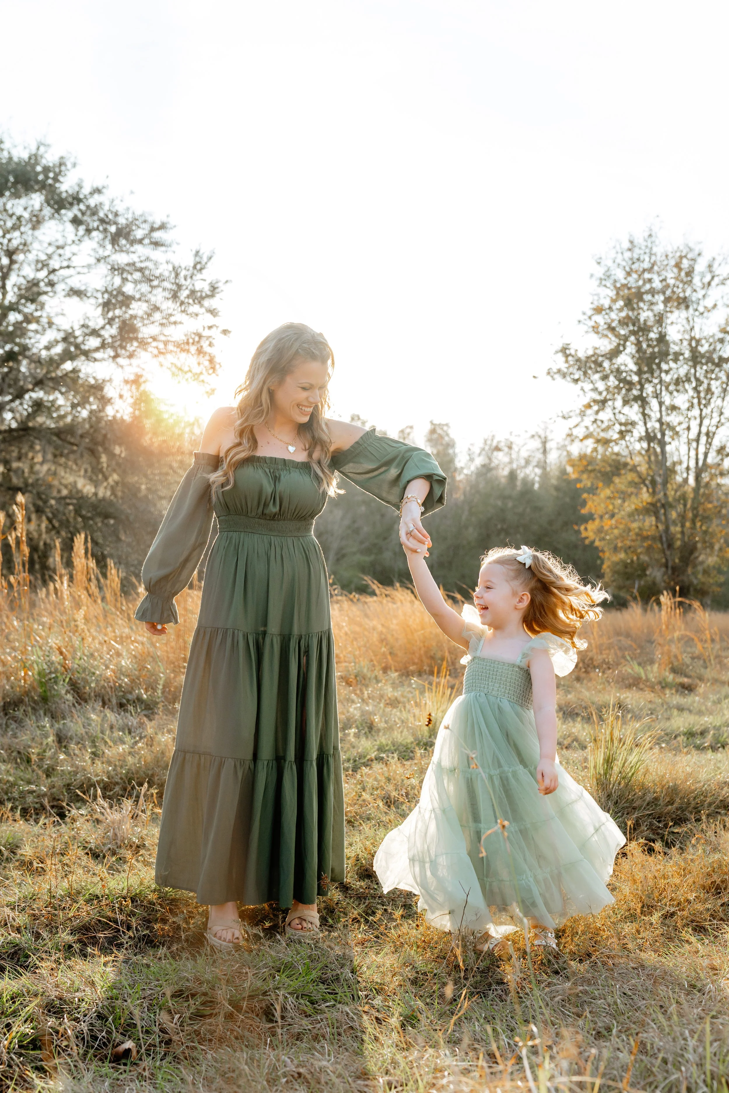 mom twirls young daughter during professional family photography session in Wesley Chapel florida