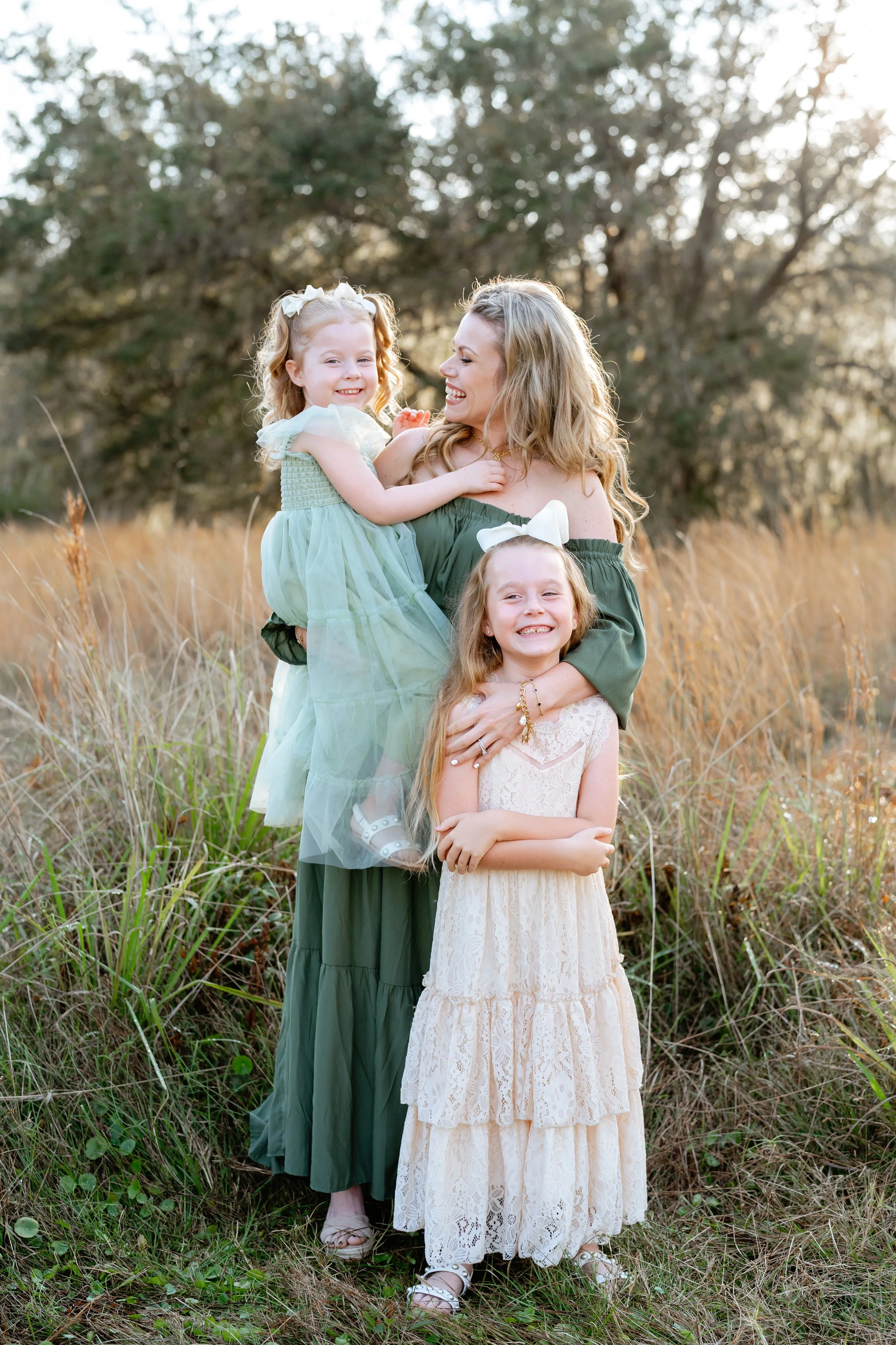 mom and two daughters pose for family photos near tampa florida