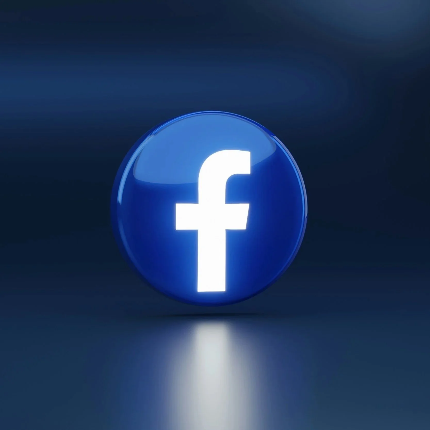 Facebook logo illuminated on a dark background.