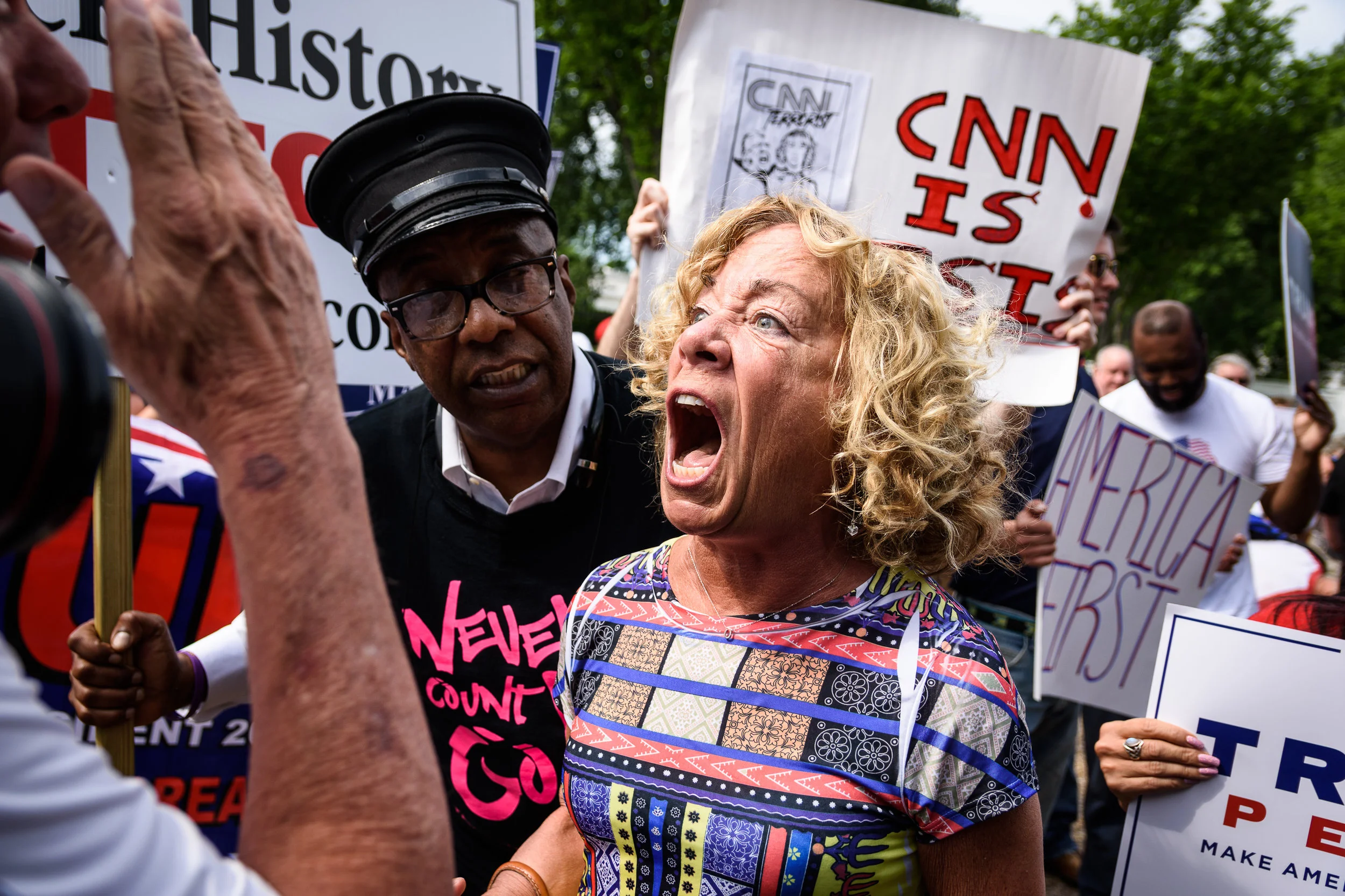 A woman disrupts the pro-Trump rally in a brief moment of tension, screaming "Trump has no clothes on" at the top of her lungs. She was escorted out by a tour guide (left) without incident.
