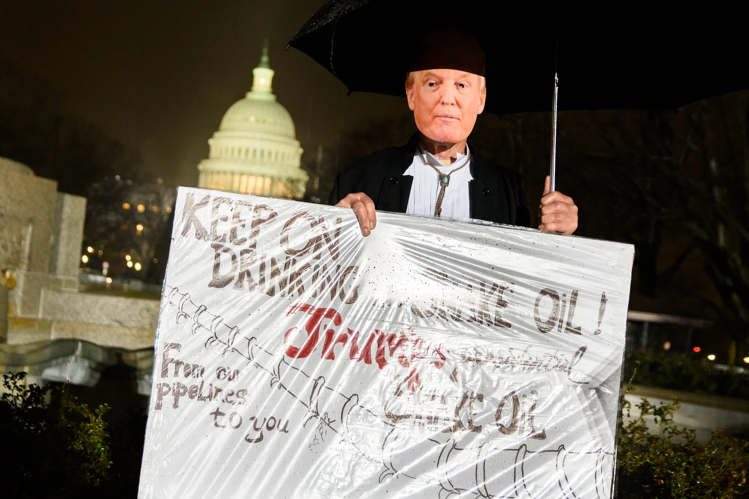 John Barrows, with his Trump mask and "snake oil" sign, frequently many Washington-area protests against Trump.