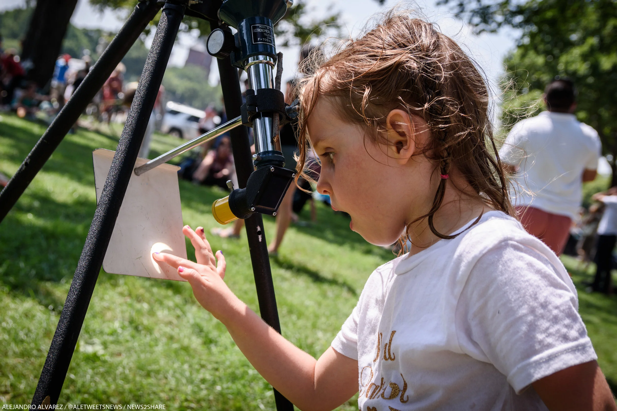 A young girl touches the Sun - or, at least, a projection of it, set up by her father on the National Mall during Monday's solar eclipse.