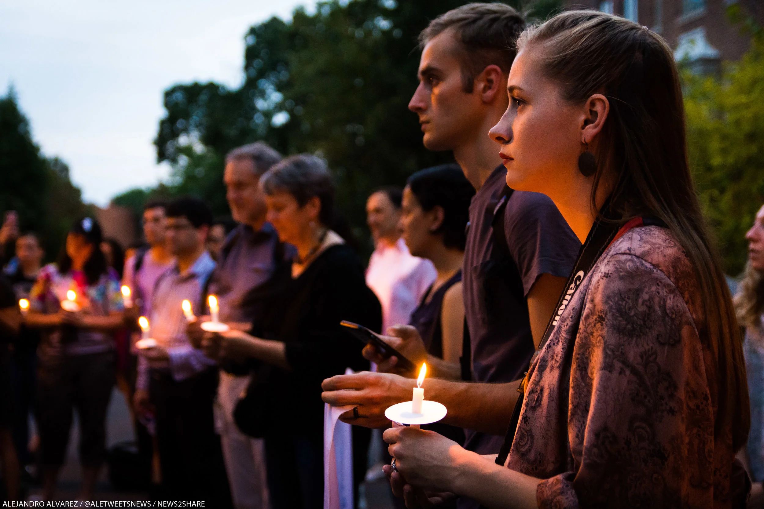 Vigil participants hold candles for Harvey victims outside former ExxonMobil CEO Rex Tillerson's home.