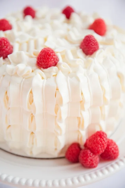 White Almond Sour Cream Cake filled with mascarpone whipped cream and fresh raspberry puree.