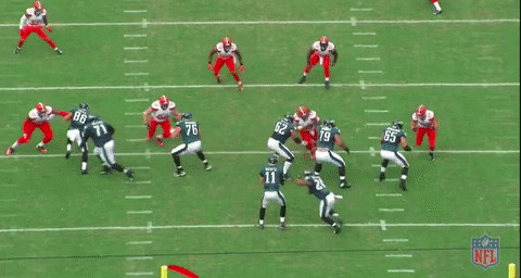 The QB is throwing the ball away because he scrambles to the right before tossing the ball out of bounds.