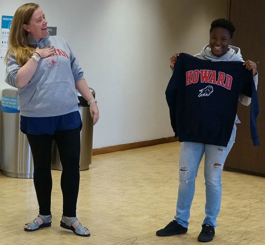 BEAM staffer Lynn hands Eli their Howard sweatshirt. 