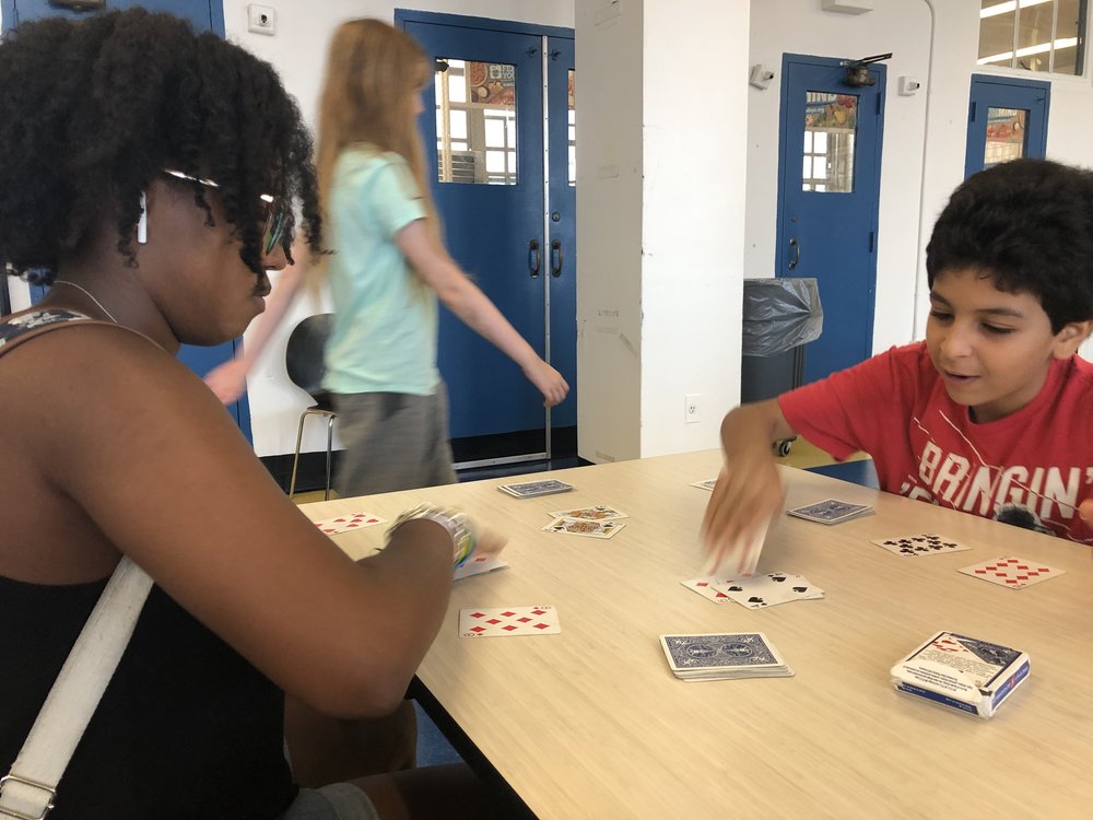  Zeñia plays cards with a student during lunchtime at BEAM Discovery. 