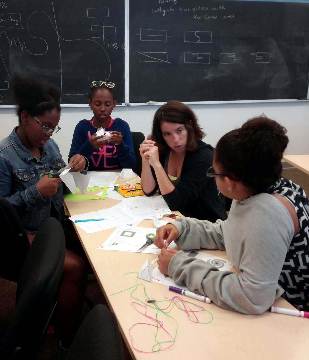  Zeñia attended BEAM Summer Away in 2014. She is pictured second from the left, wearing sunglasses on her head and working on a paper geometry project. 