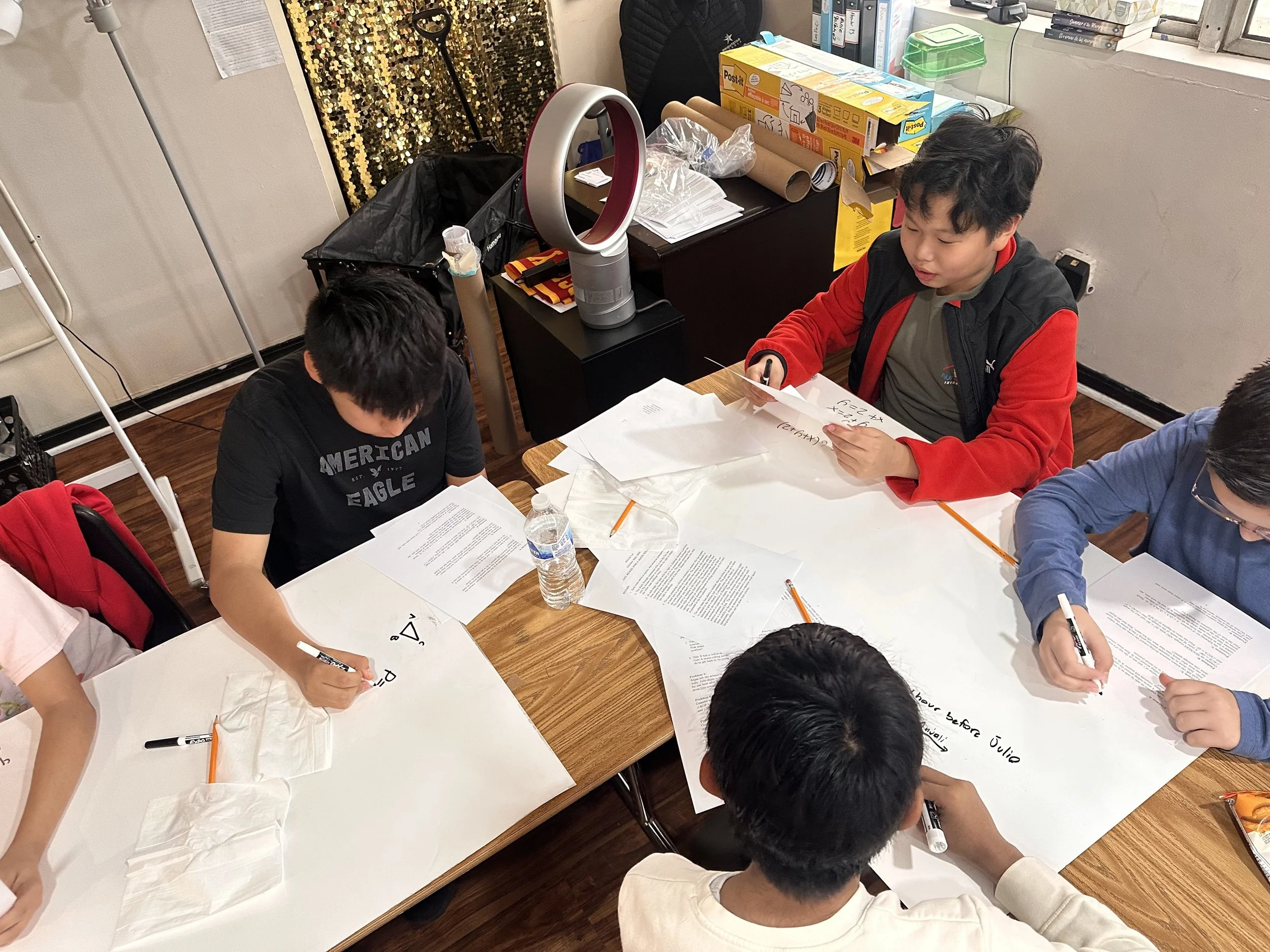  8th-graders in LA work hard to complete a problem during a math relay.  
