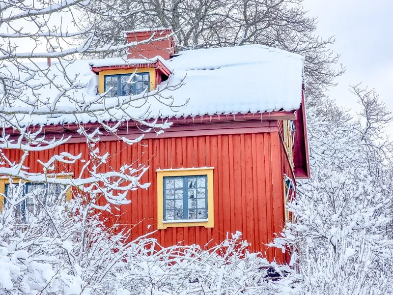 традиционные красные домики в скансене, стокгольм, в снегу зимой.jpg