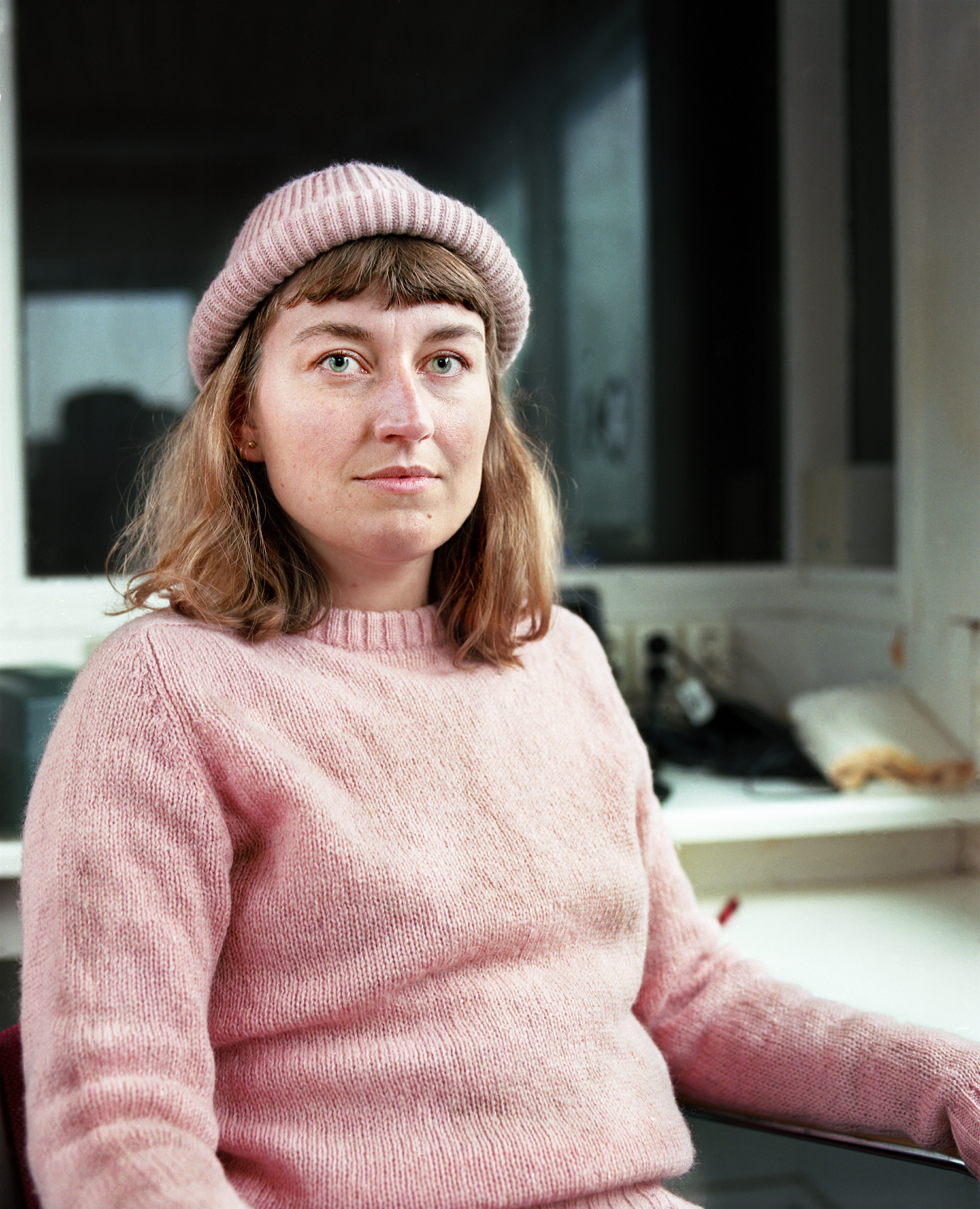 Nanna is from Denmark but currently calls Seyðisfjörður home. I lived in the loft which was actually the hallway to Nanna's room. When she wasn't working on her art she was working at the local hostel or ferry. It was pouring rain the day I made this portrait. I had walked over to her ticket booth to bring her warmer clothes.