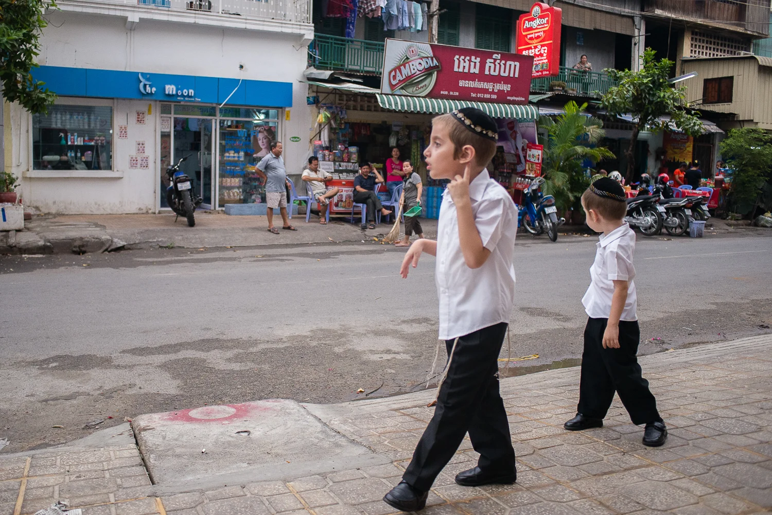 Zalman and his younger brother Shmulik outside their home in Phnom Penh, on their way to walk to Shul (the Jewish Center and Synagogue) down the street. Because the Butmans' observe the Sabbath and do not use transport for 24 hours, their home needs to be close to the center. 