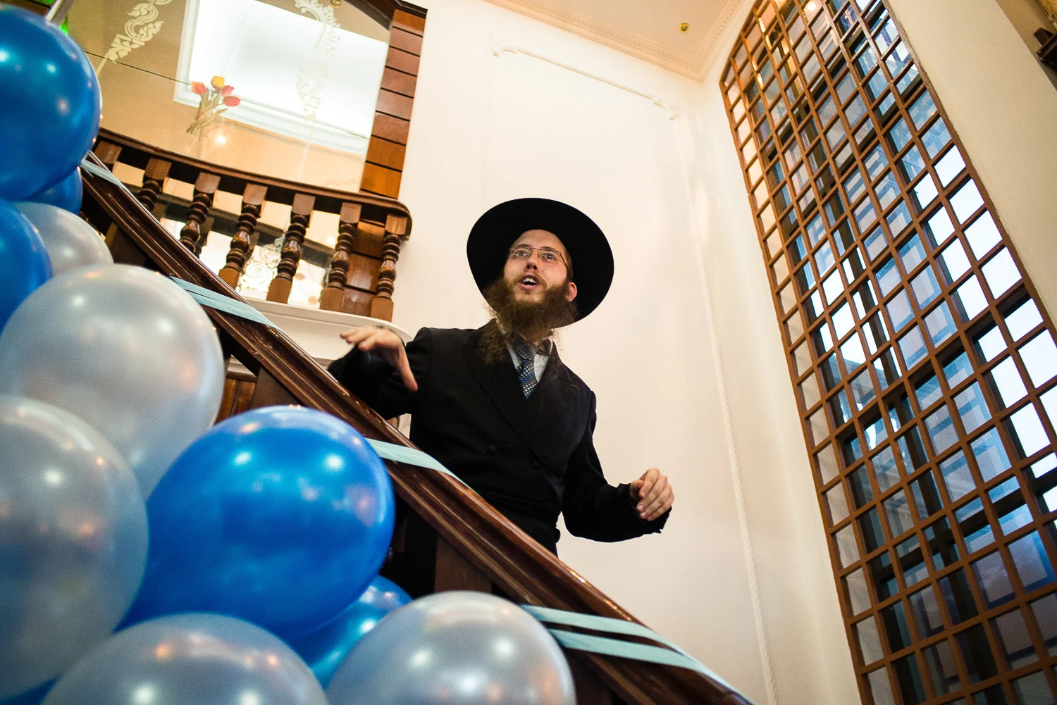 Rabbi Butman comes downstairs from the prayer room at the Chabad Center to invite all men upstairs to pray before the Bris (circumcision ceremony) of his newly born son.