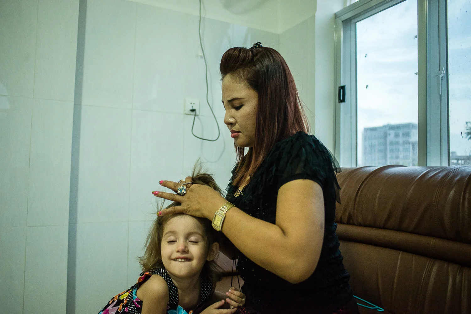 The Butmans have a Cambodian helper, Lily, to assist with childcare and cooking. Here, she helps Henya get ready for Shabbat. 