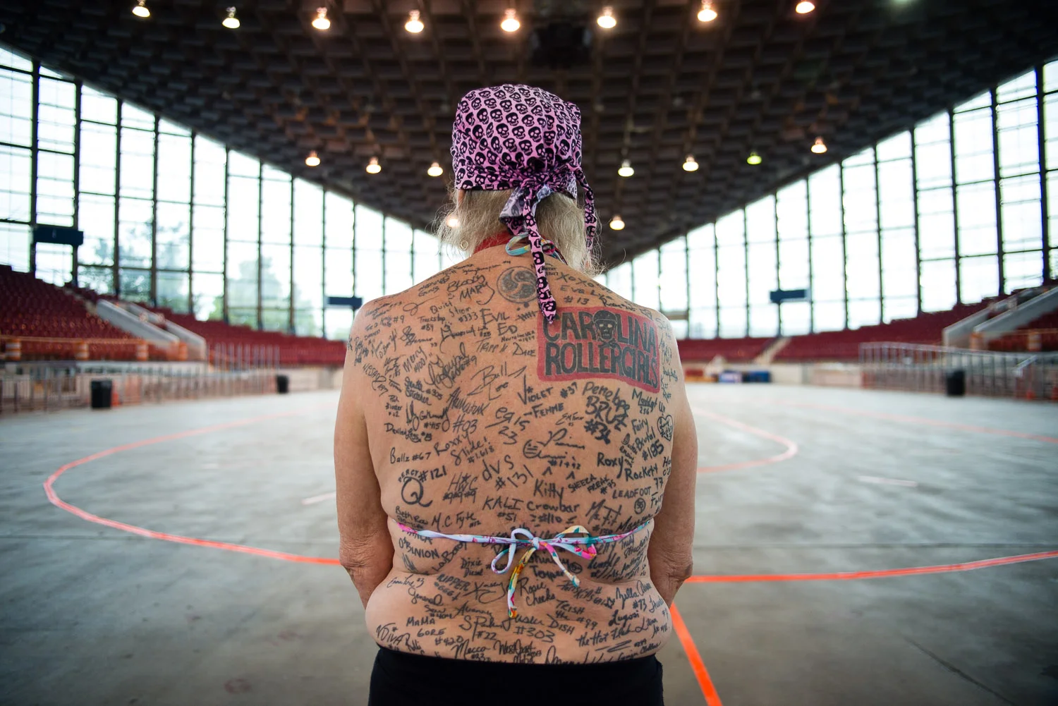 "Double X Factor" used to play roller derby, and now volunteers at most games running the penalty box. On her back are tatooed signatures from players she respects and admires. "It is a HUGE honor to be on her back", says one CRG player. 