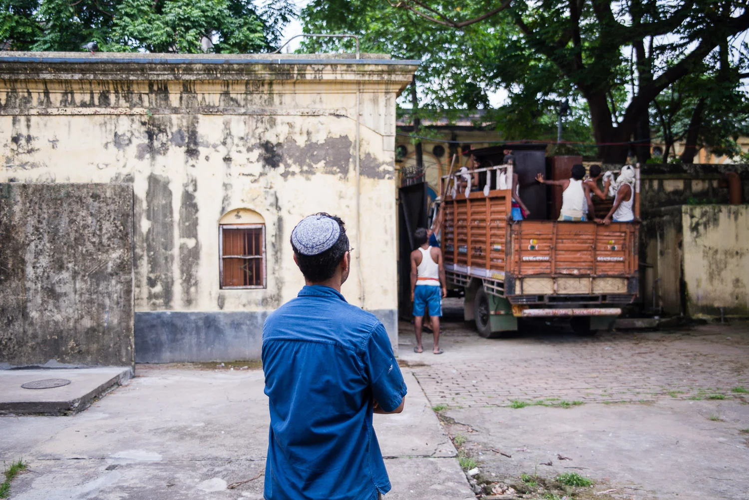 Shalom observes the movers taking the majority of his furniture away. Many of the pieces he fixed up himself over several years time.