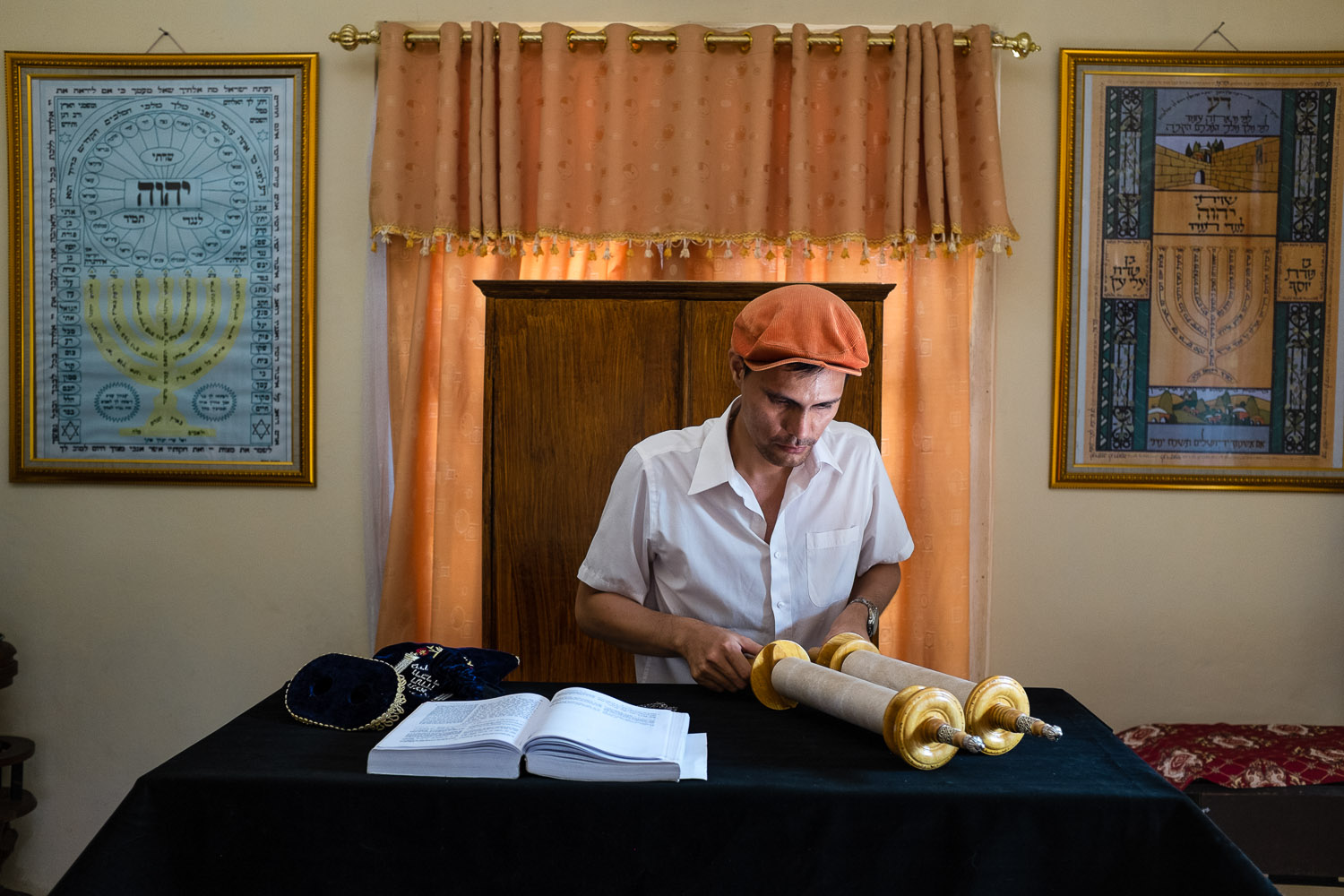   Vicky Ratumbanua (Avshalom) opens his Torah scroll in his home synagogue in Manado, North Sulawesi, Indonesia.  