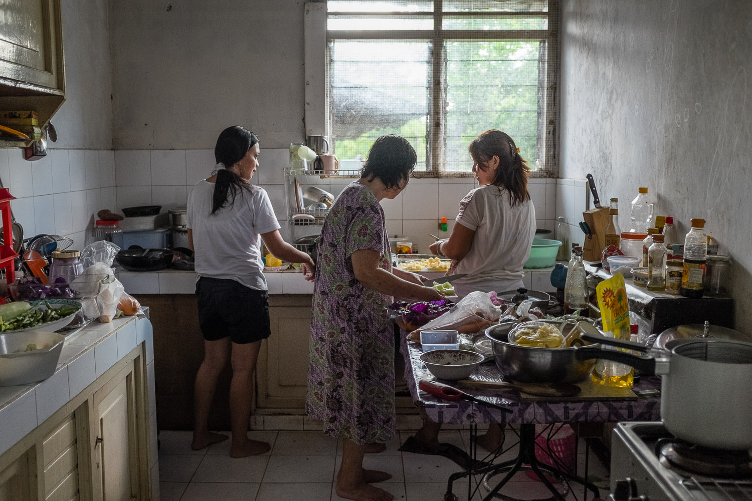   Vicktor's wife Ingrid Sumampow (Rakhel), Vicktor and Vicky's mother Margaretha N Watuseke (Khanah), and Ingrid's sister prepare the Shabbat meal in the Rambutuana home in Manado, Sulawesi.  