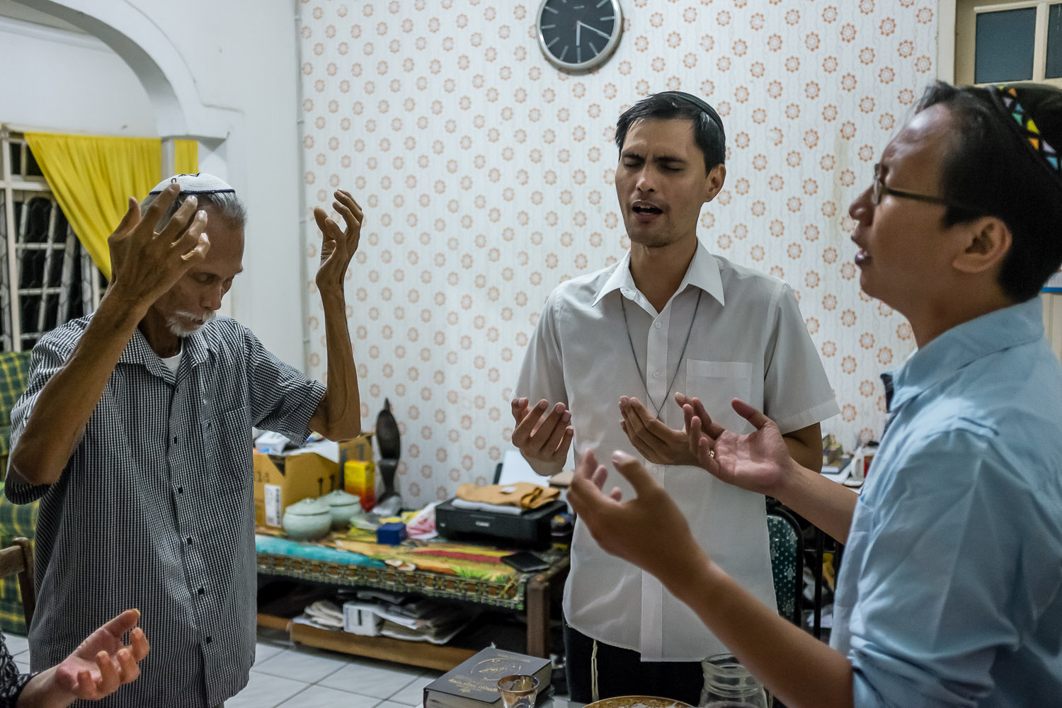   Vicky (Avshalom), Vicktor (Noakh), and their father Ferdinand (Benayahu) recite the Shabbat prayers.  