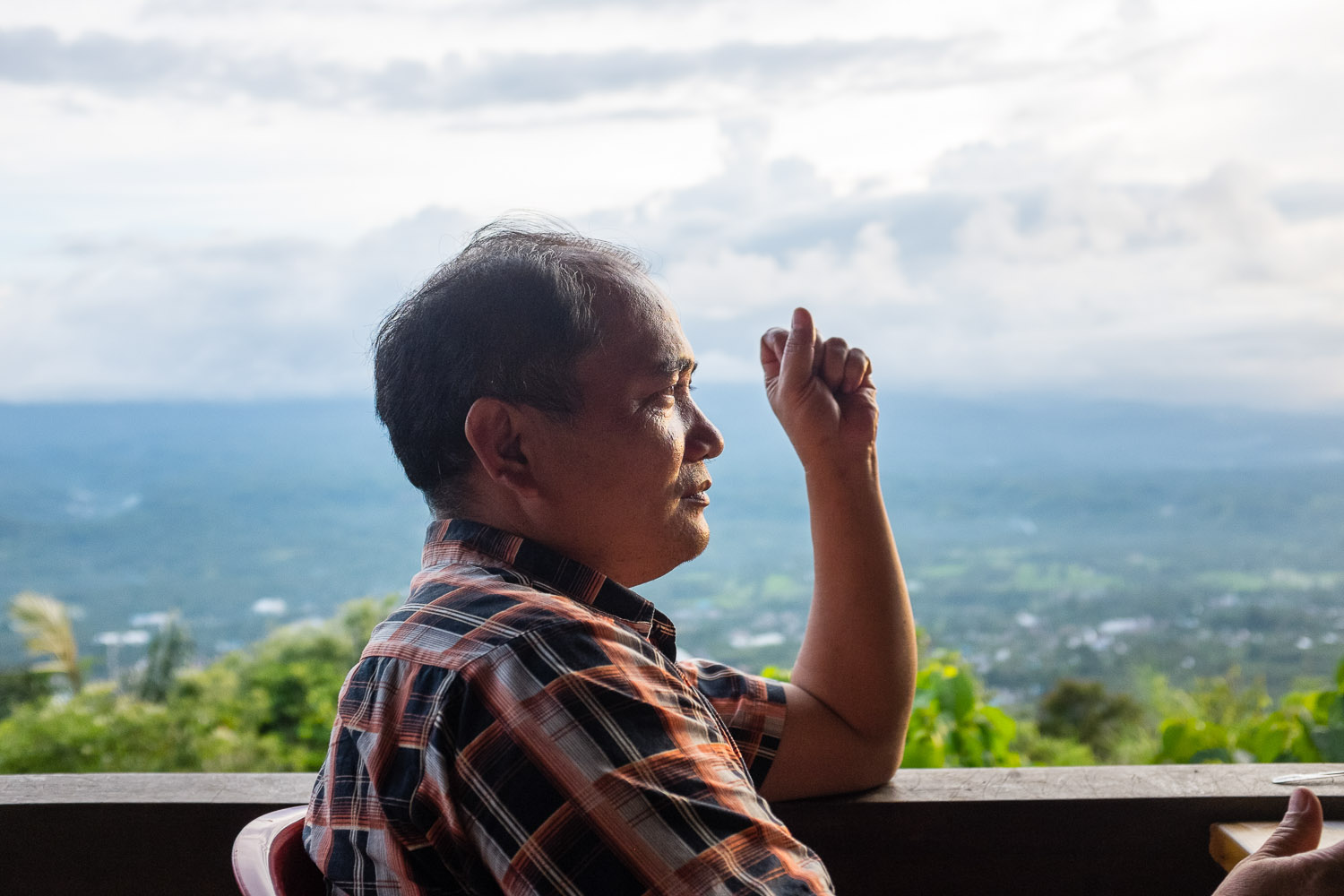   Ezra Sengkey, who came to be with his family and Vicky's after praying elsewhere, looks out over Sulawesi from the cafe next to a 62 meter high menorah, which was placed on one of Manado's highest mountains as a sign for the city's love of Israel.&