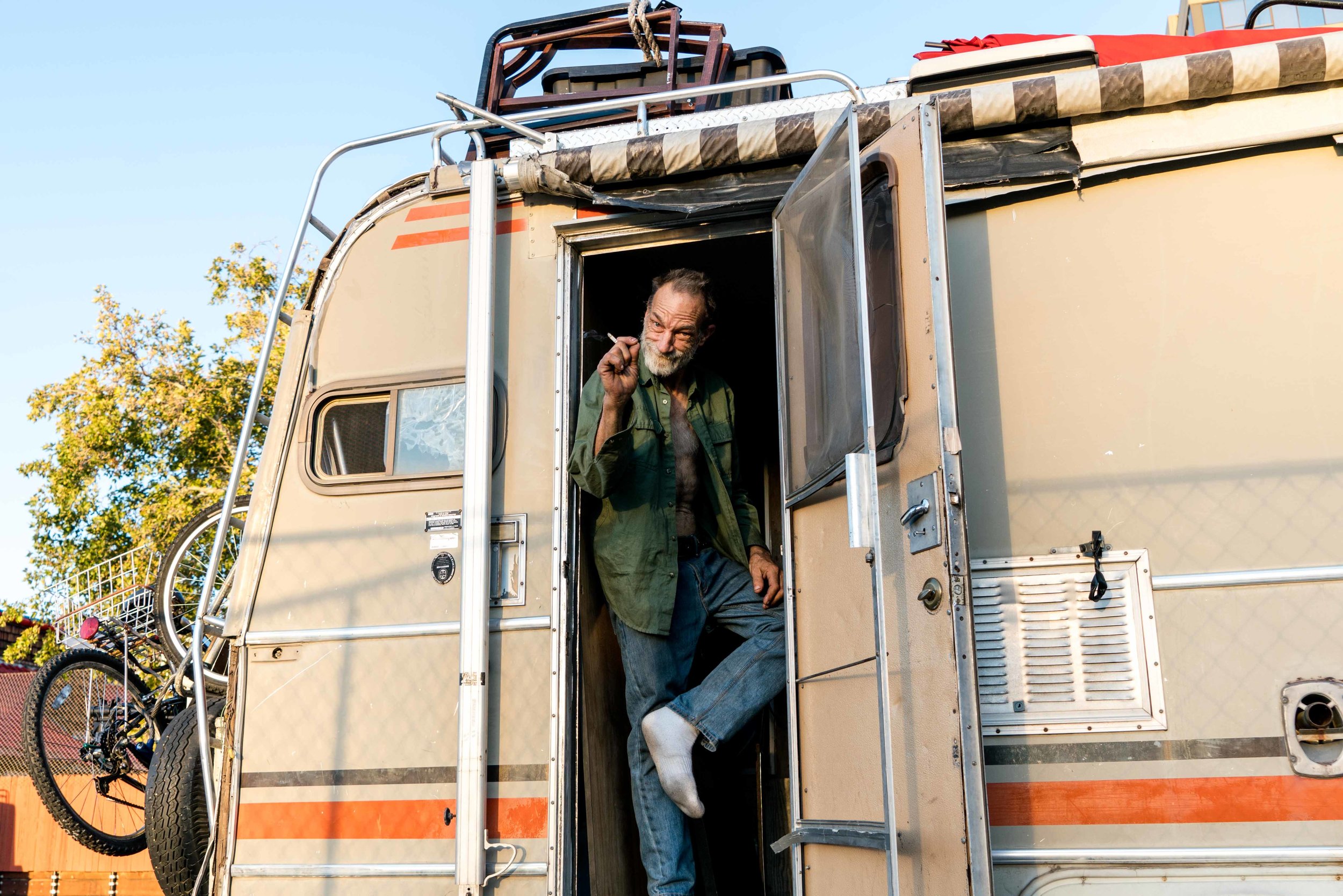 “I call her ugly,” B*. says as he motions to his 1980s home on wheels, which he got from a “God-fearing-man” last December. B. is a street guitarist who recently left his job as a plumber at the Tesla factory. He says “Ugly” is the best thing that ever happened to him because it allowed him to keep pursuing music in Reno.