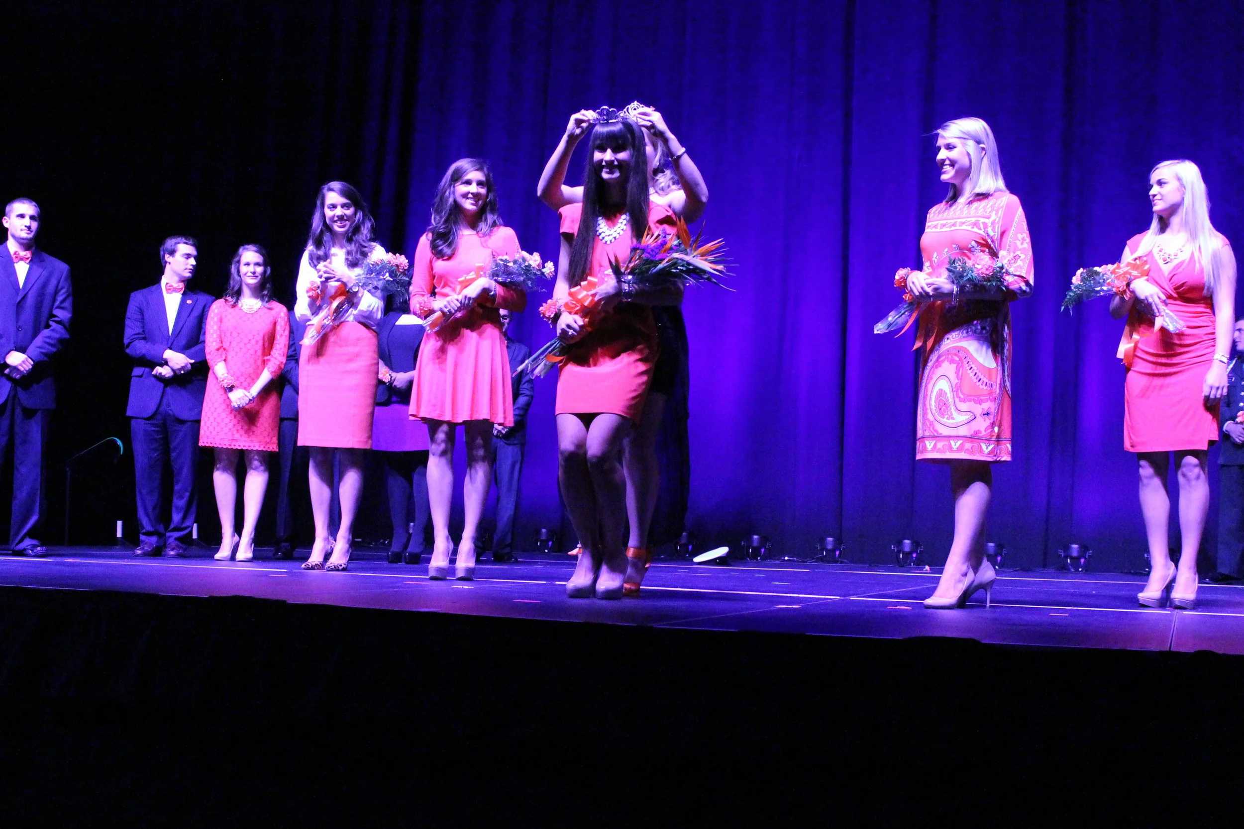 Canon Rebel T3 with 18-55mm kit lens Settings: 35mm, f/5, 1/200 second, ISO 6400, custom white balance set before the lighting changed, no flash, manual focus, shot in JPEG Side note: those dresses are all orange.