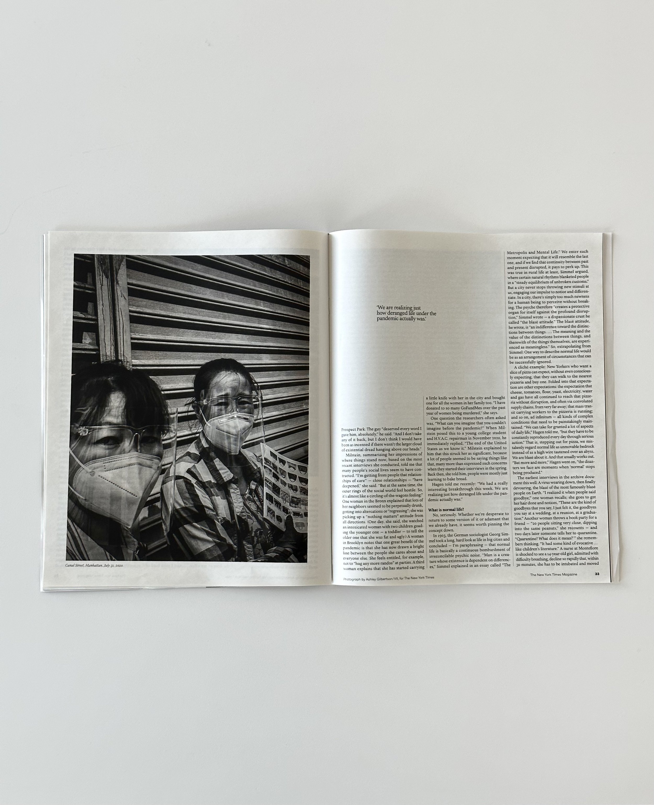  New York Times Magazine opened. Black and white image of people in masks on left side, text on the right. 
