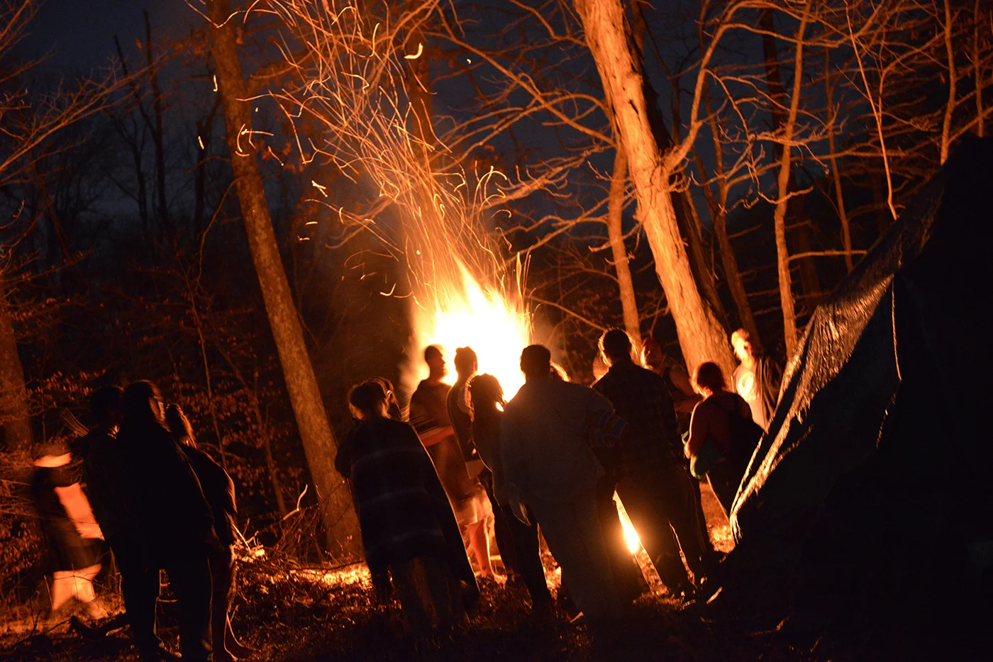 Members of the Wiccan community gather around the fire before participating in the reawakening plunge into Lake Gaia, named after the mother of life. They lit a fire to keep warm after going into the lake and sang songs to celebrate Imbolc. The plunge is a spiritual experience that represents rebirth into the spring. 