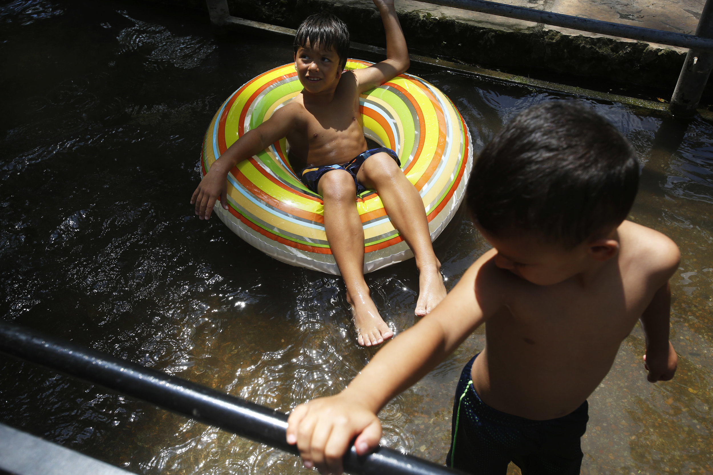 Marcelo Allen, 7, and Jayden Garza, 4, play in the water at Landa Park on Tuesday, May 15, 2018.
