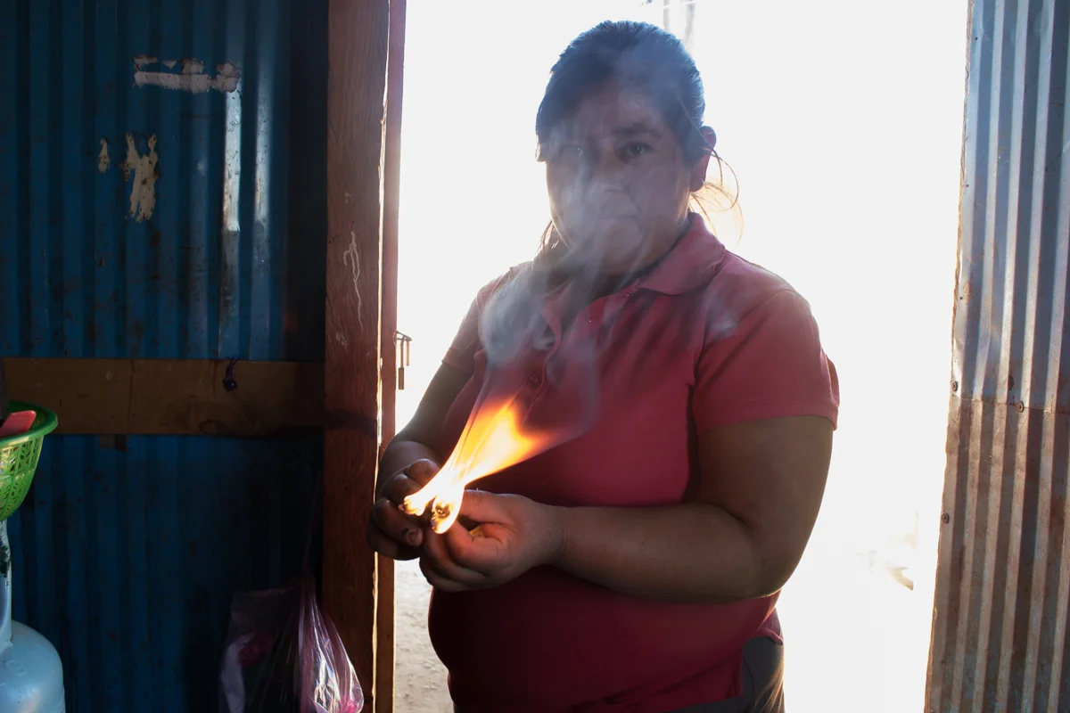 Herminia Vargas, 32, burns wood in preparation to light her stove to cook dinner in Zaachila, Mexico on Thursday, Jan. 12, 2017.