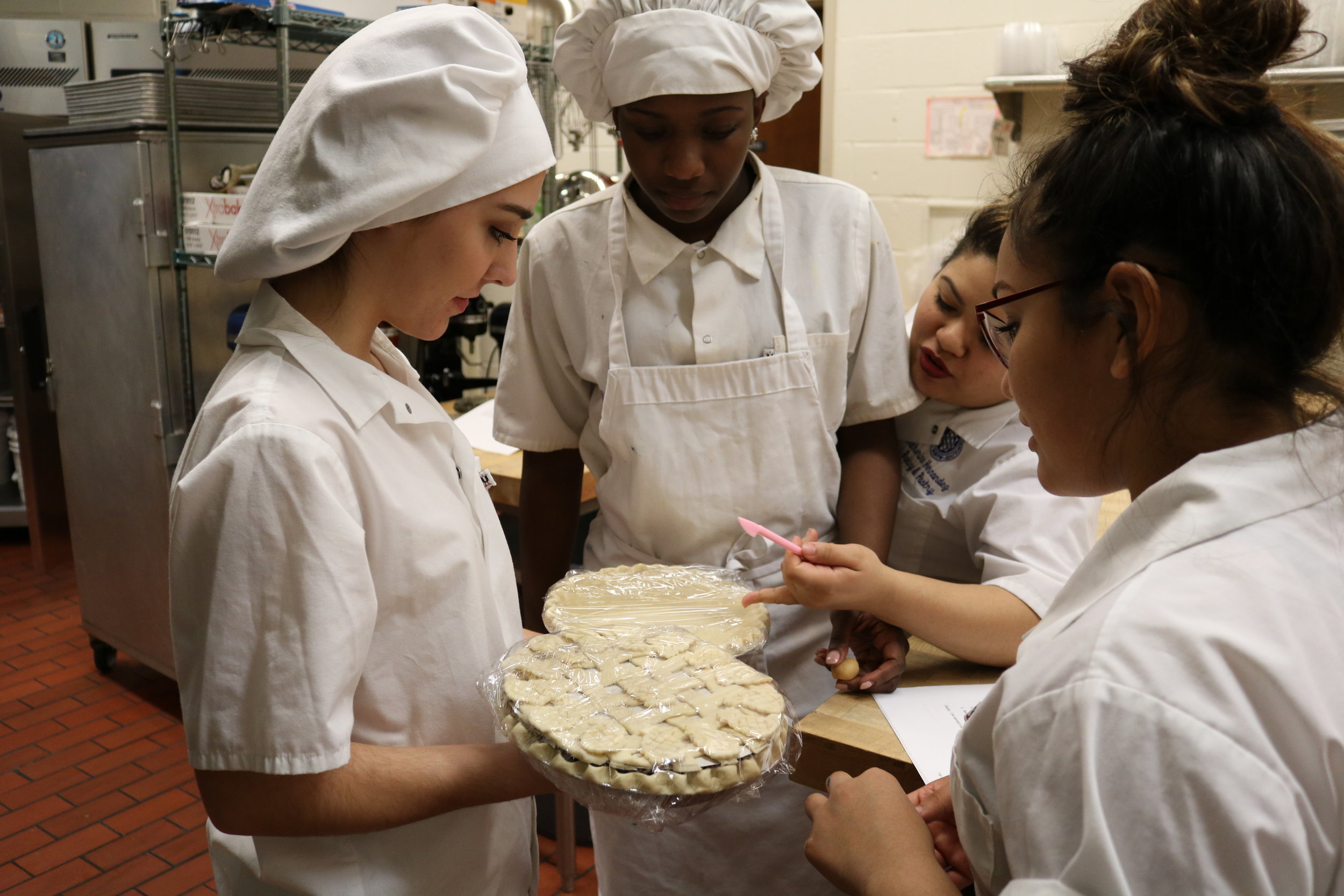   Ally Berrich, left, shows the pies she baked to her classmates at the Center of Applied Technology North in Severn, Md., on May 11, 2016.  