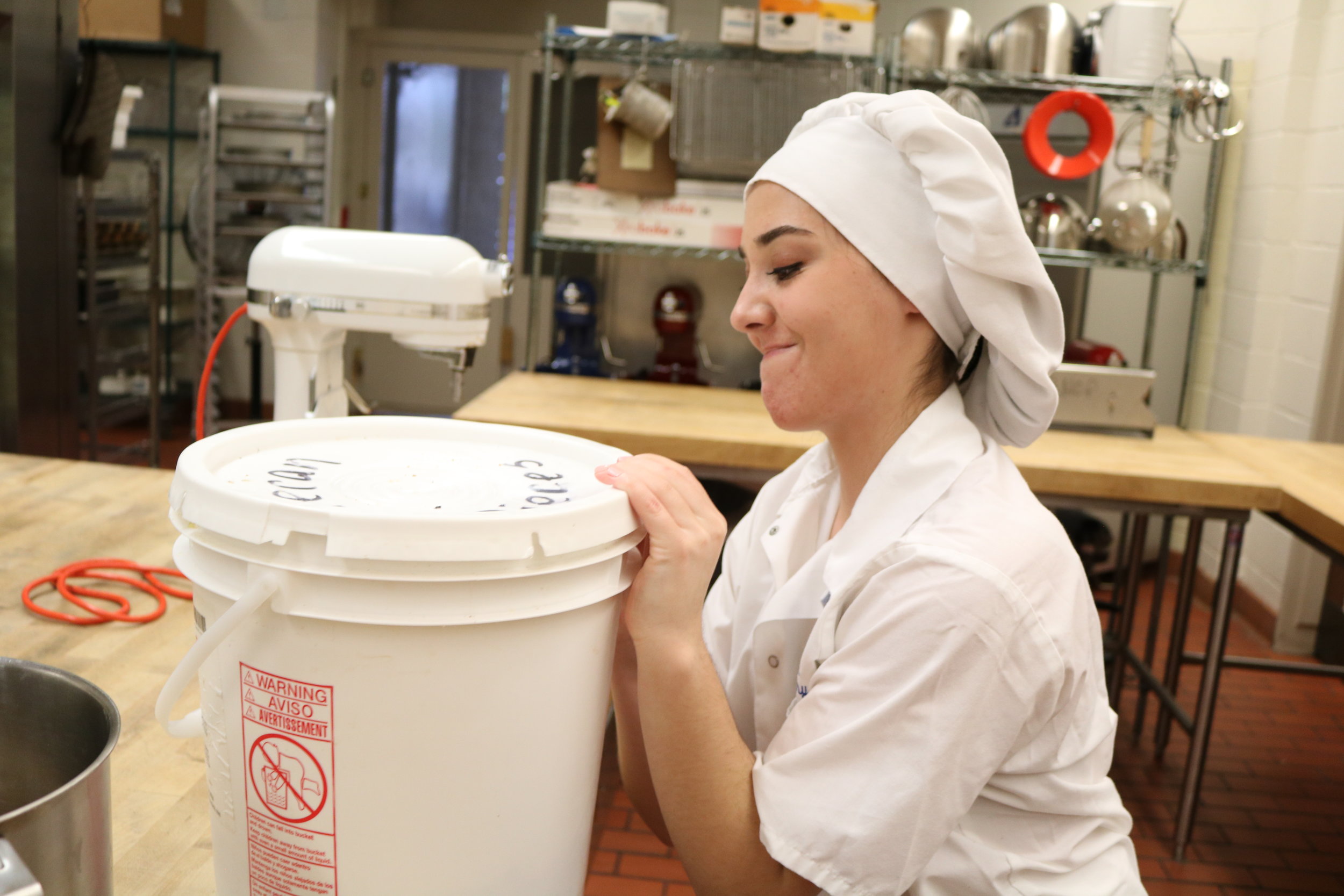   Ally Berrich, 17, works to open a tub of dough to bake for a commercial order in her baking and pastry course at the Center of Applied Technology North in Severn, Md., on May 5, 2016.  