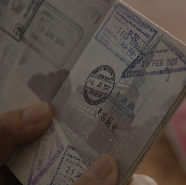 241215 Looking at Passport and photos.600x600 - Megumi Nishikura.png