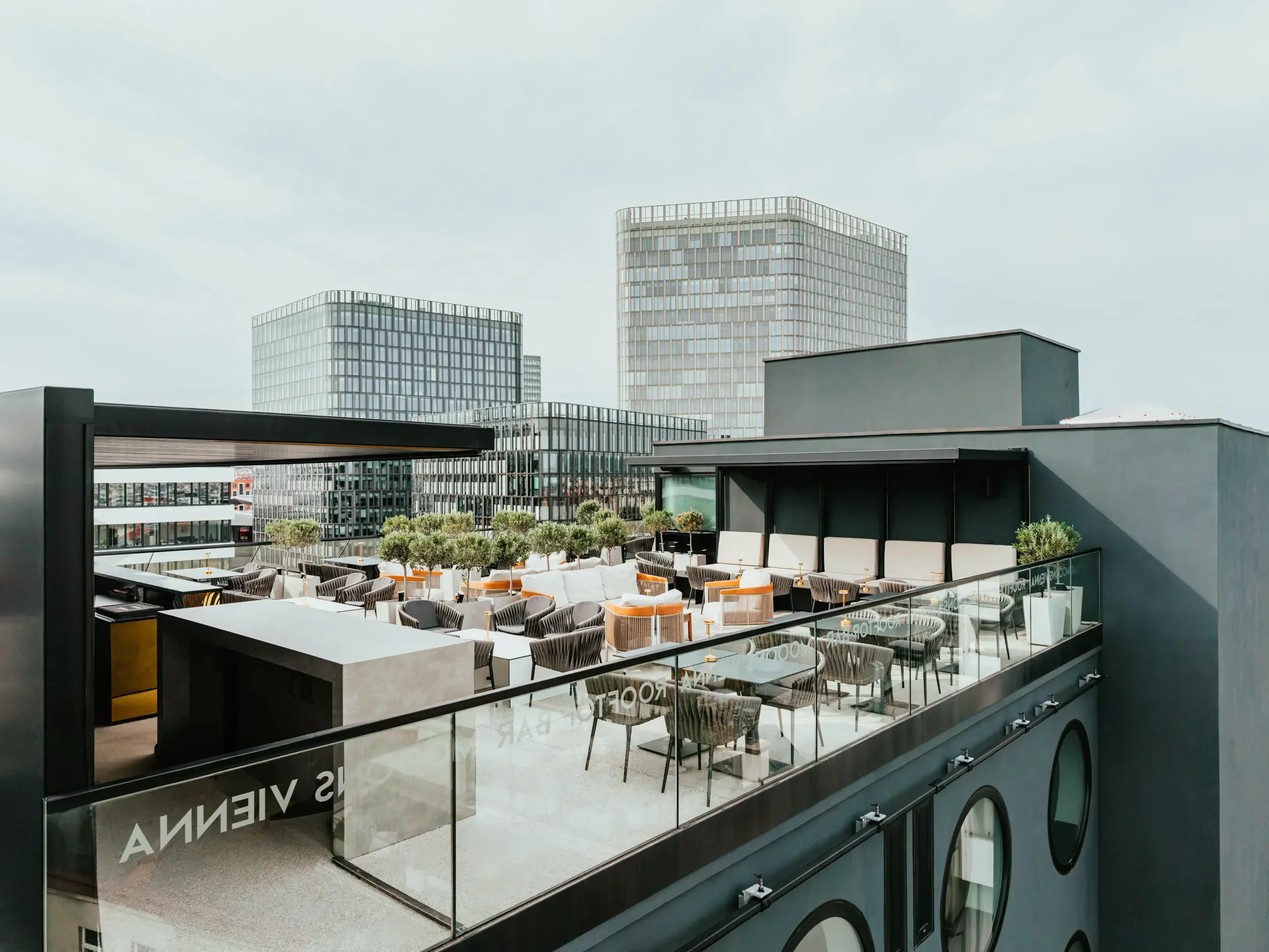 MOOONS Vienna Rooftop Bar vor einer Skyline aus gläsernen Bürogebäuden
