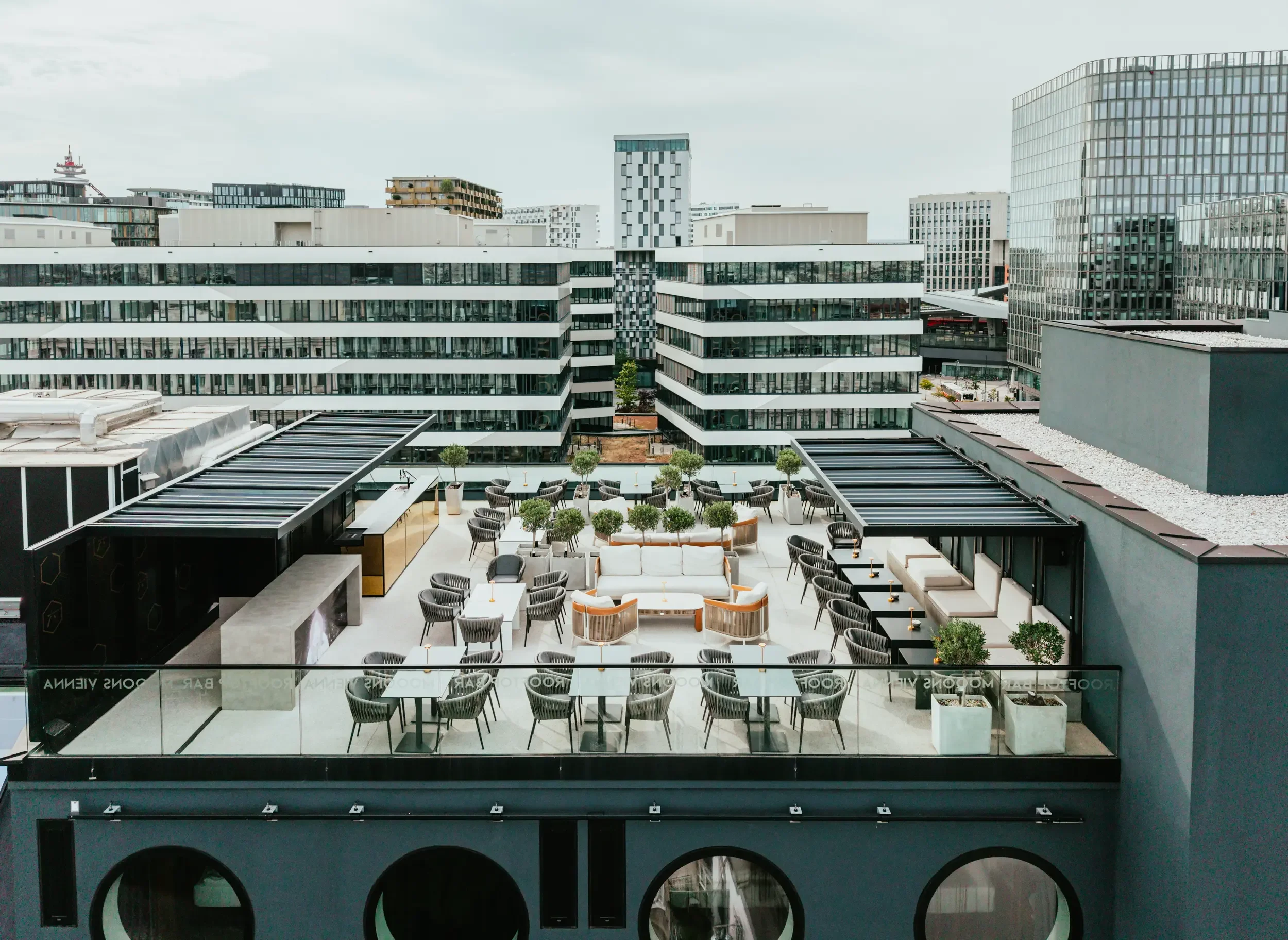 Moderne Dachterrasse mit Sitzbereich und Blick auf die umliegende Stadtkulisse im Mooons Vienna
