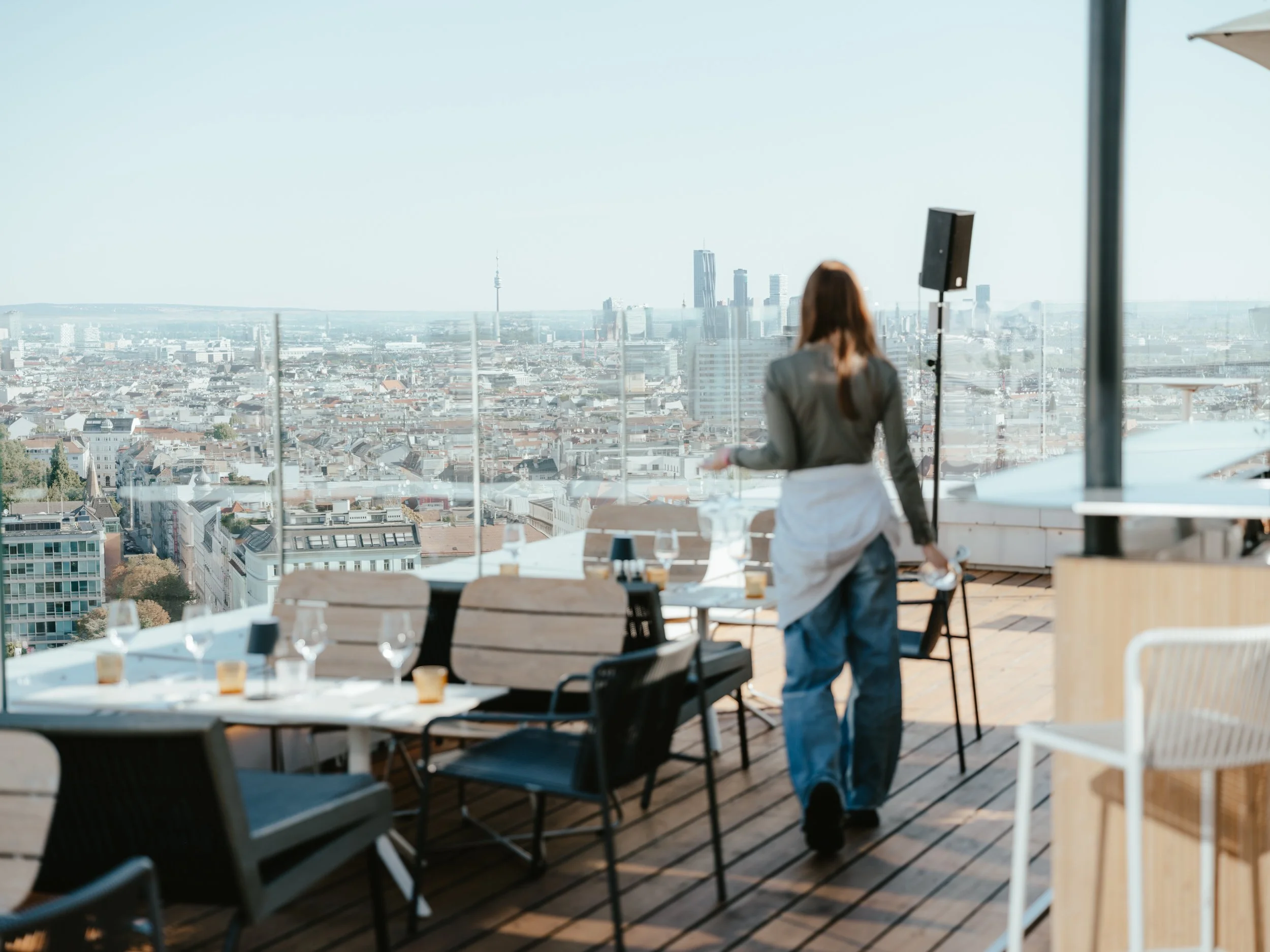 Kellnerin auf der Dachterrasse des Hyatt Regency Vienna mit Blick auf die Wiener Skyline
